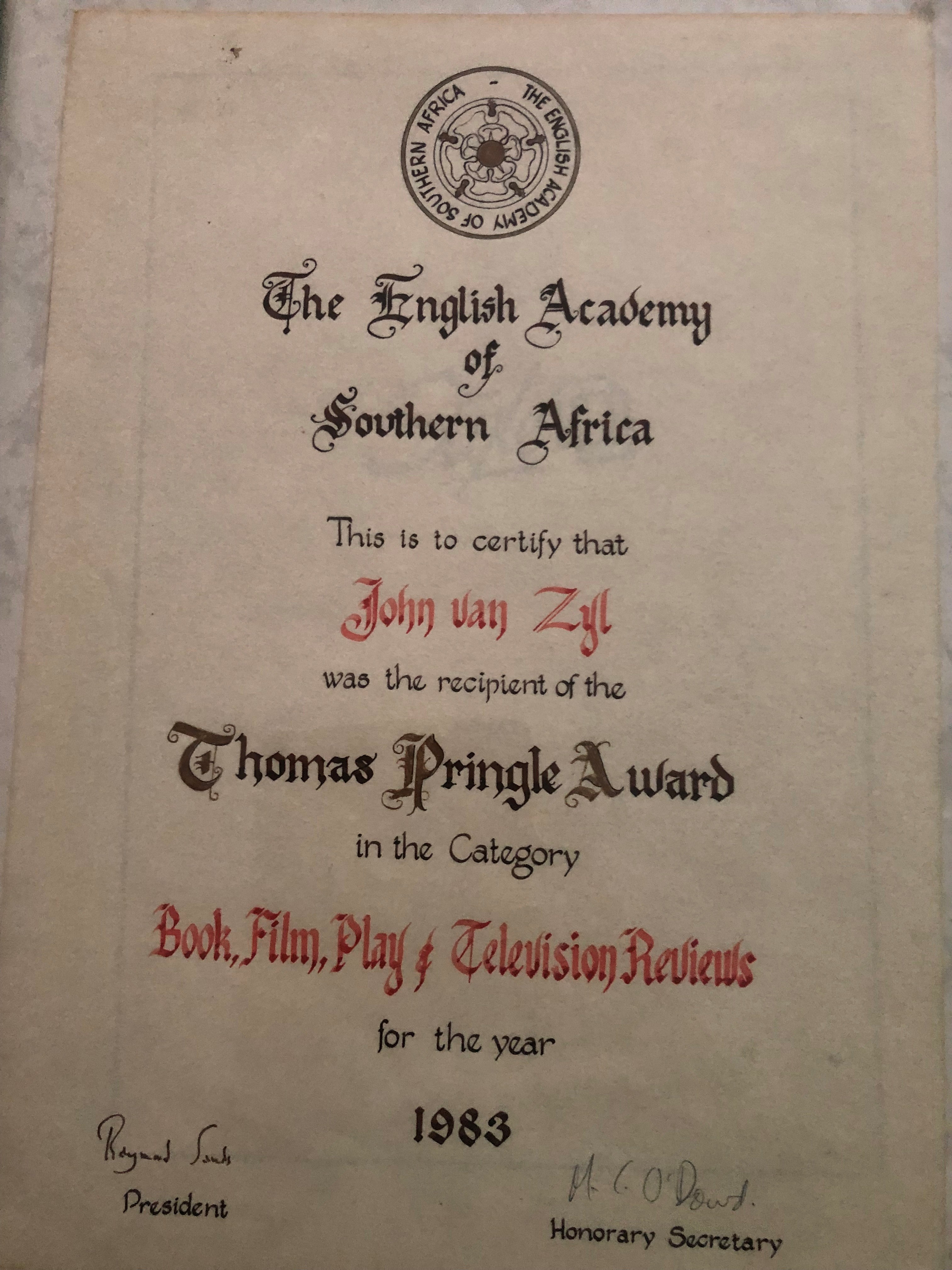 The image is of John's Thomas Pringle Award certificate. It reads: 'The English Academy of Southern Africa. This is to certify that John van Zyl was the recipient of the Thomas Pringle Award in the Category Book, Fil, Play & Television Reviews for the year 1983'. It is signed by the President and Honourary Secretary.