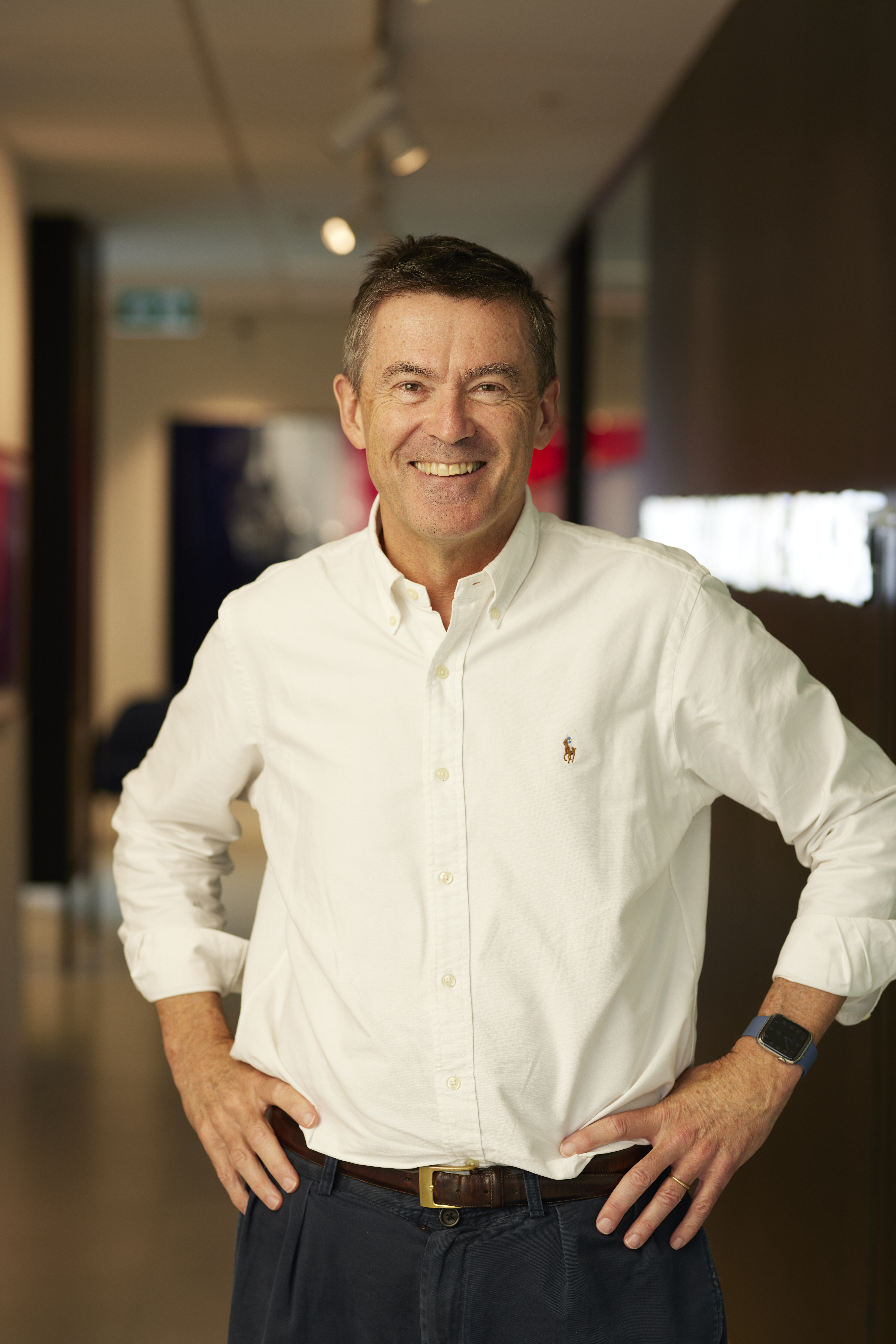 John Wylie standing and smiling with hands on hips