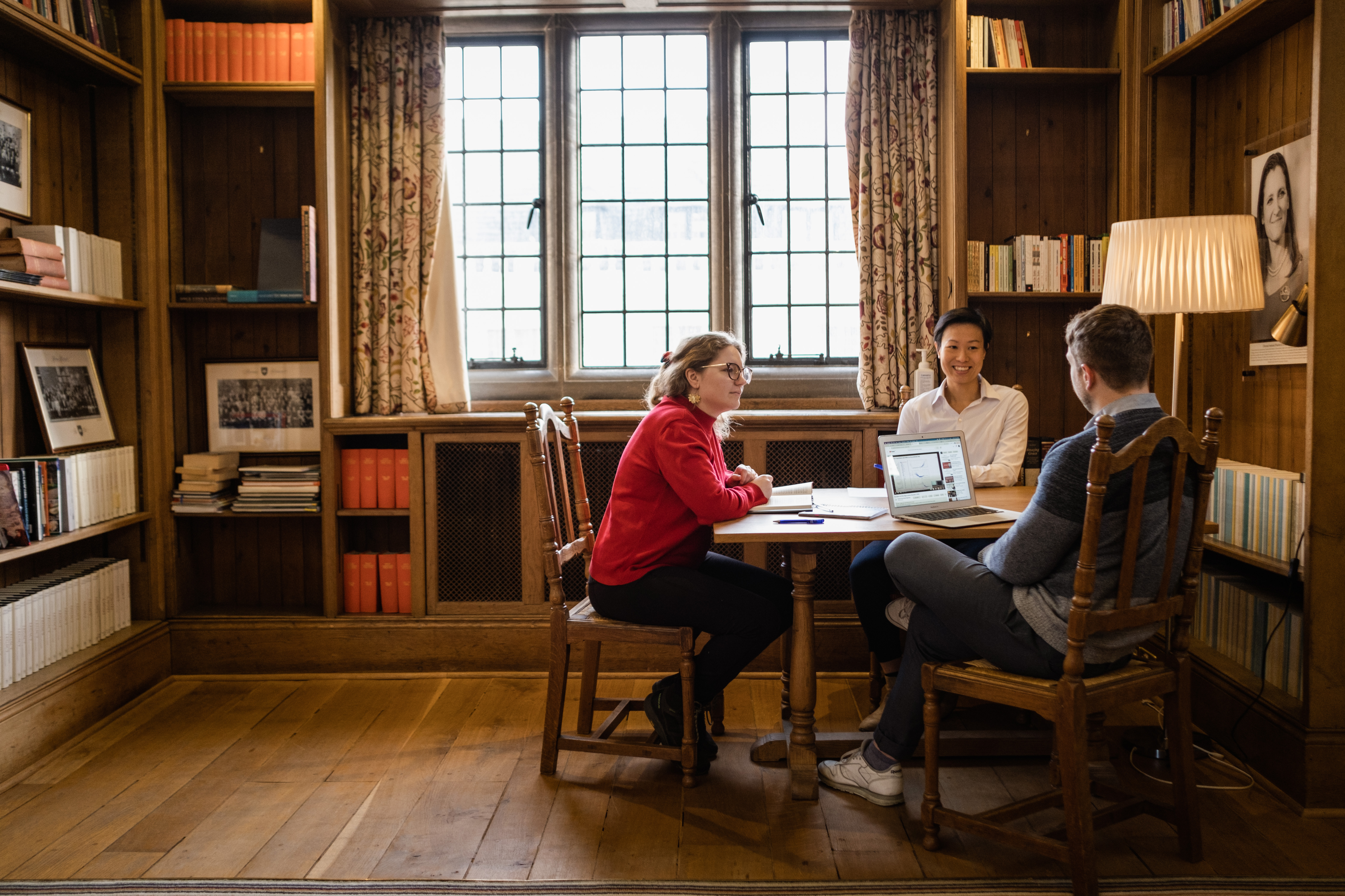 Scholars in discussion around a table in the Rosebery library