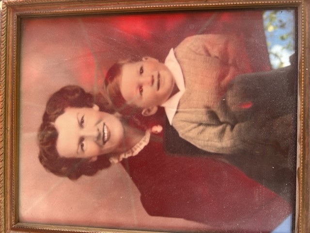 A framed photograph of a woman with a little baby in her arms. They are both smiling.