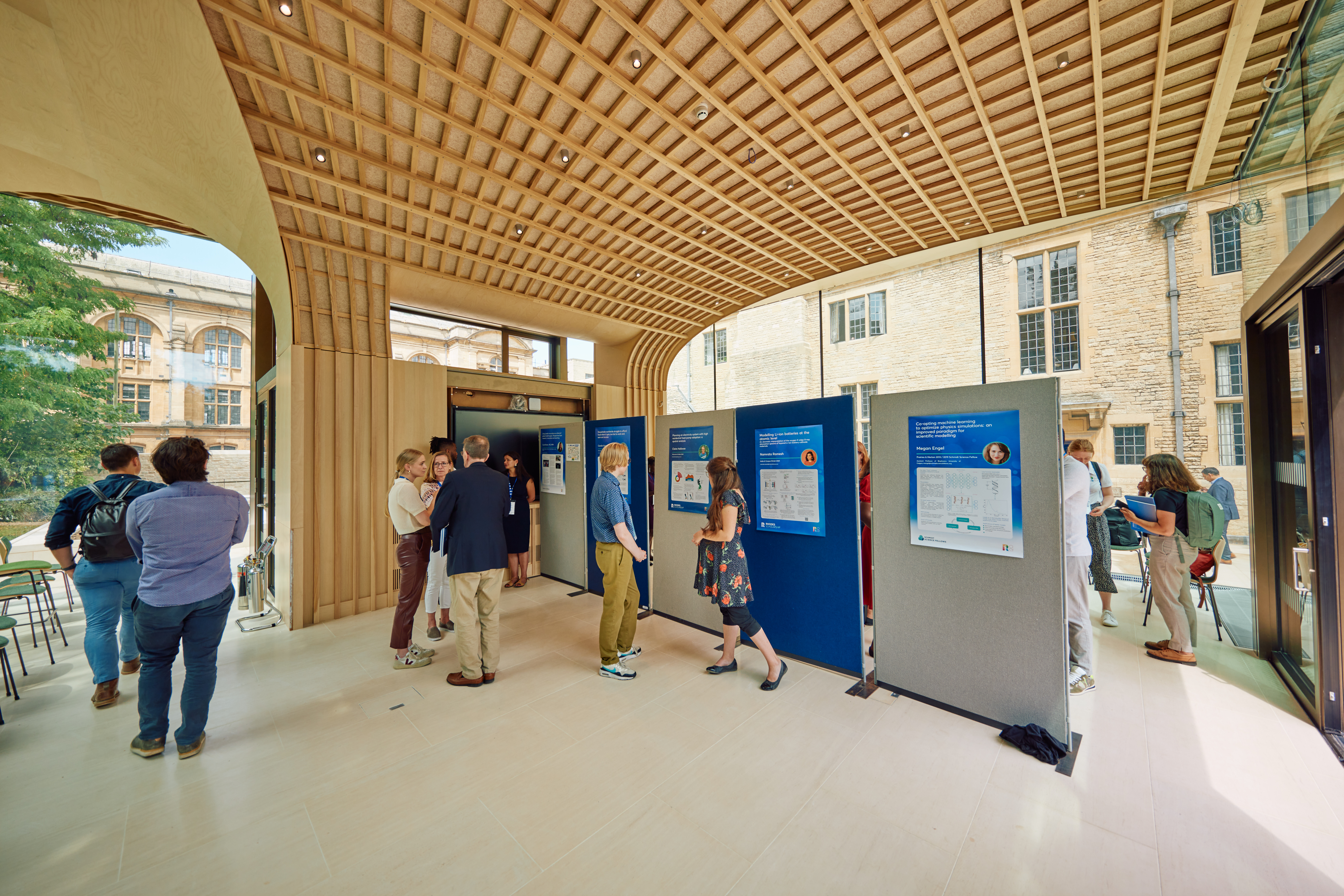 Inside view of the Rhodes House Glass Pavilion with conference delegates and exhibition boards.