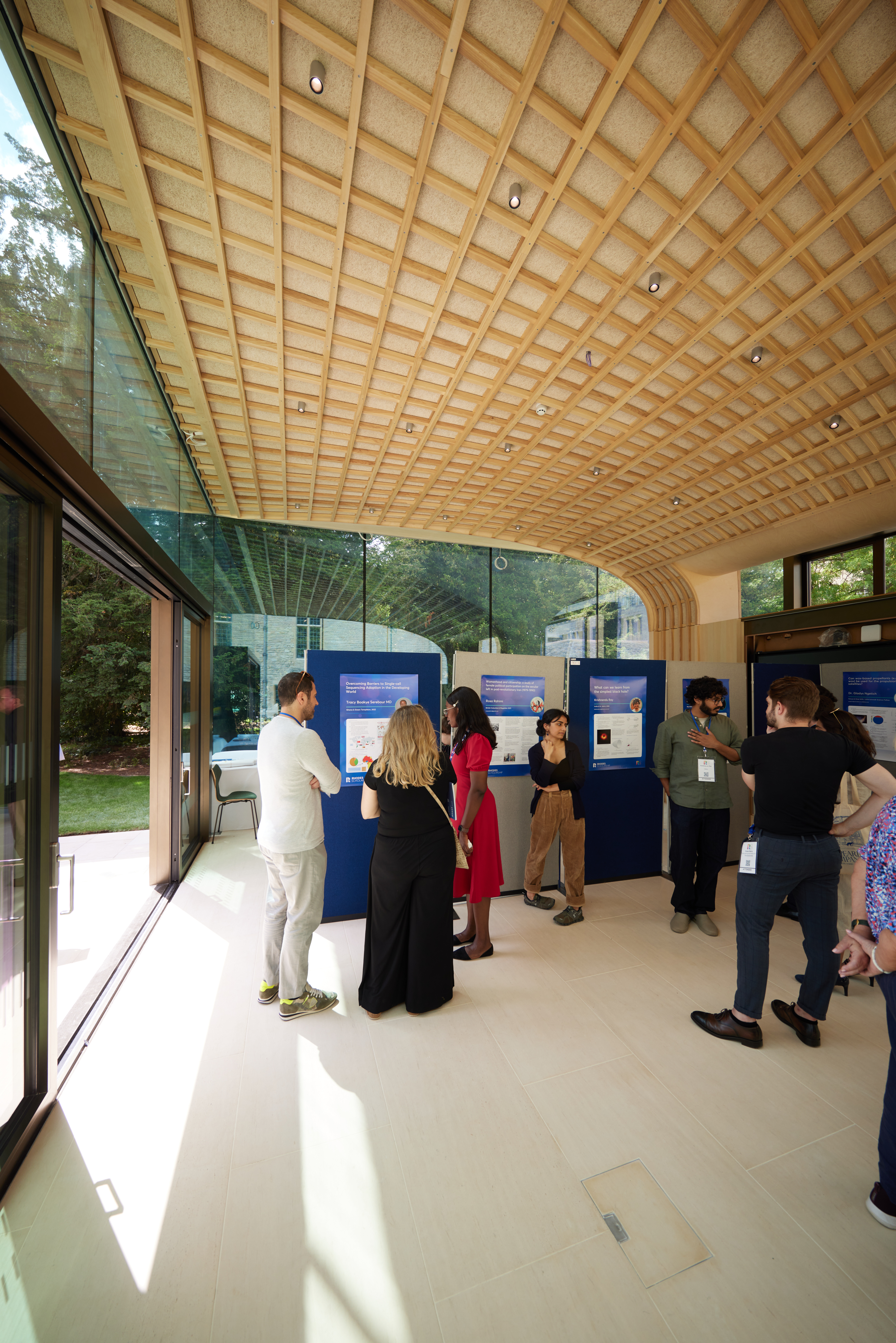 Inside view of the Rhodes House Glass Pavilion with delegates and exhibition boards.