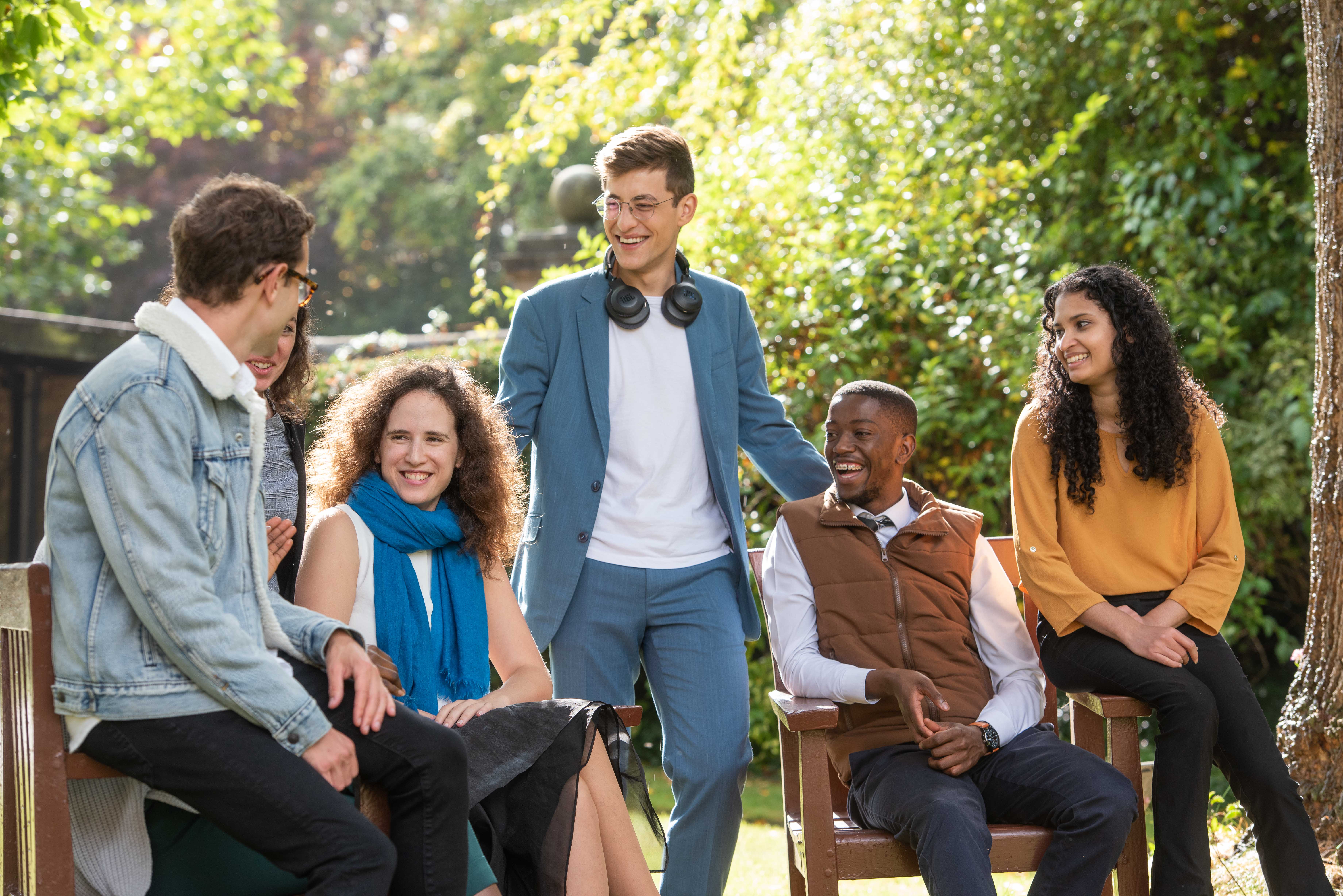An image of six Rhodes scholar students sitting outside and talking