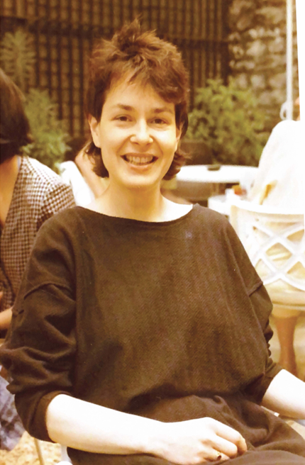 Sepia tinted photo of Elizabeth sat smiling.