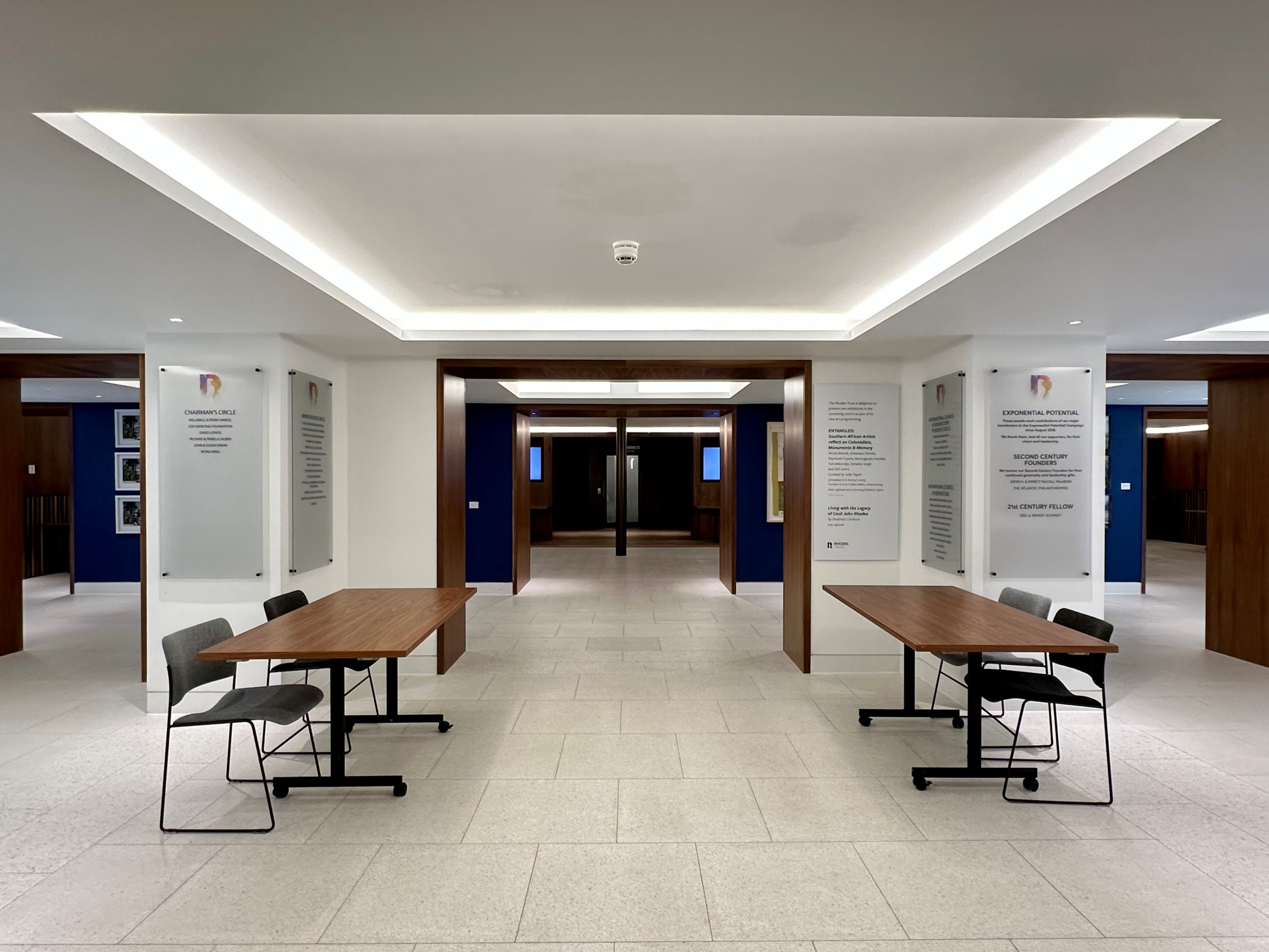Rhodes House Conference Foyer entrance area set up for a conference with two registration tables and two chairs behind each table. 
