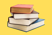 A photo of stacked books in front of a yellow background.
