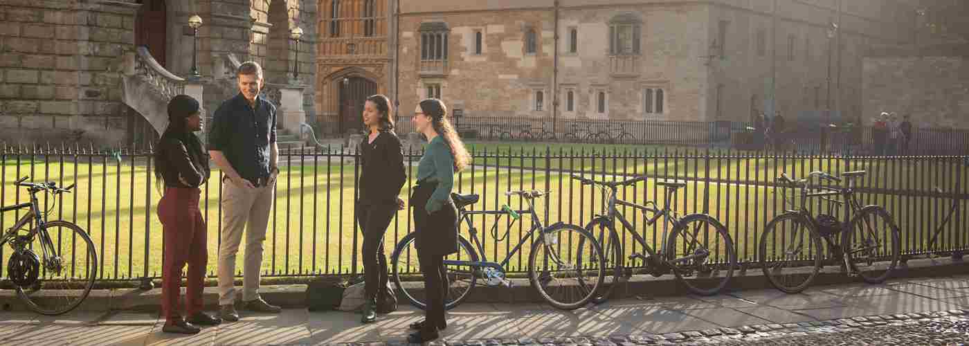Three Rhodes Scholars chatting and smiling outside of the Radcliffe Camera, Oxford.