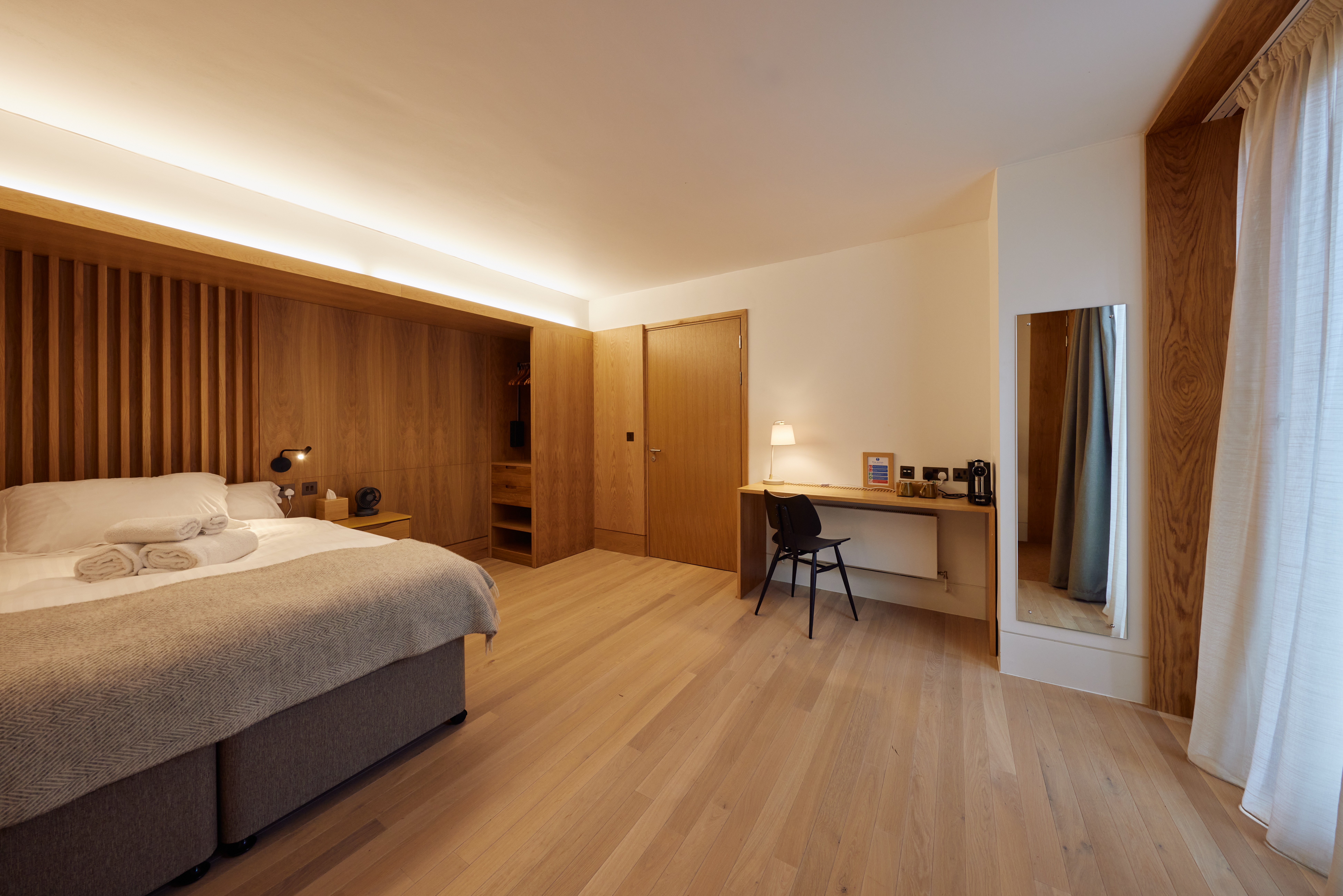 Rhodes House accommodation - -A Whole Room Shot Of One Of The Spacious Accessible Bedrooms In The Residential Courtyard; The Floor And Focal Wall Are Lined With Wooden Panels