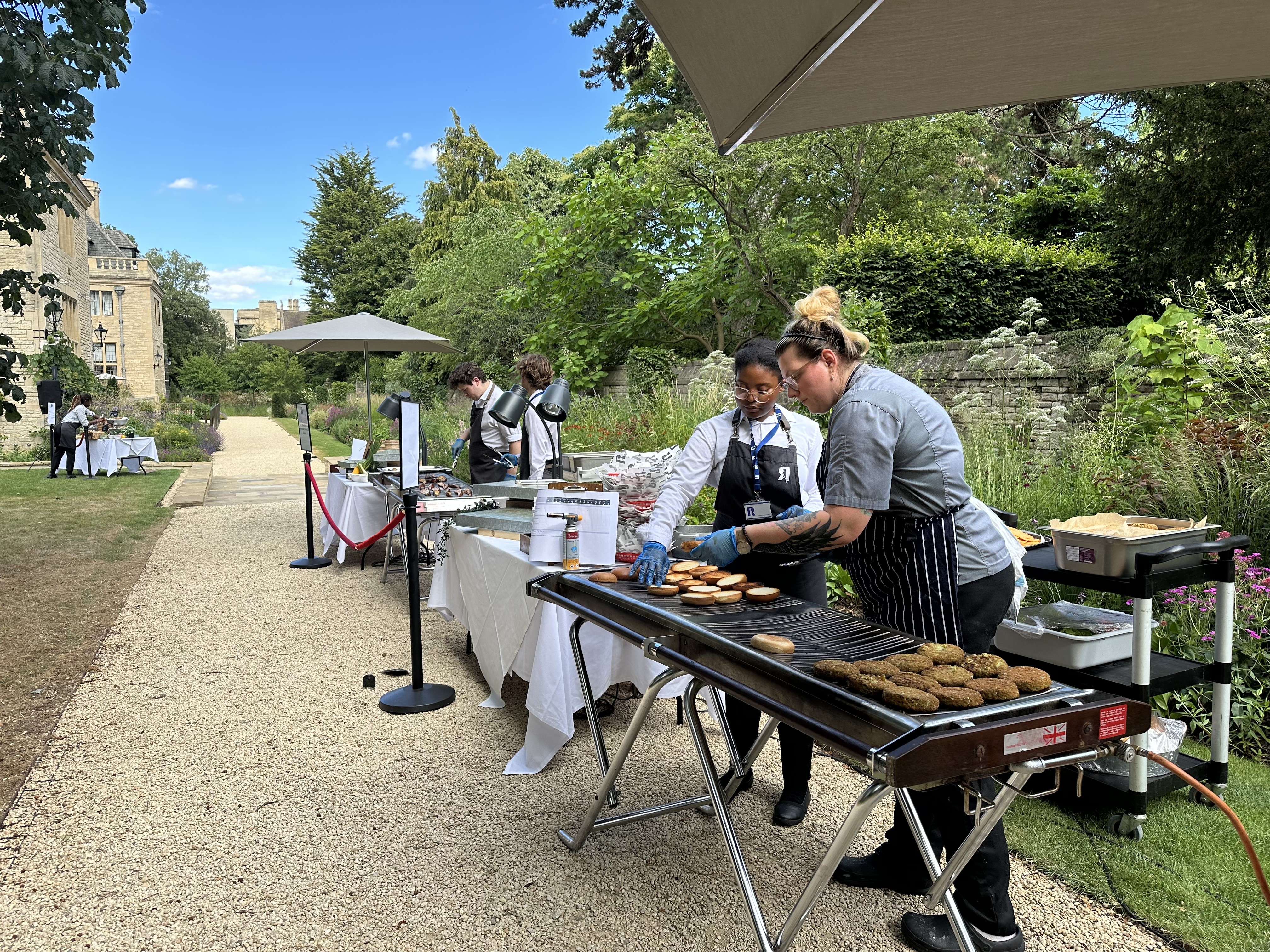 Chefs grilling veggie burgers for a BBQ in the Rhodes House garden.