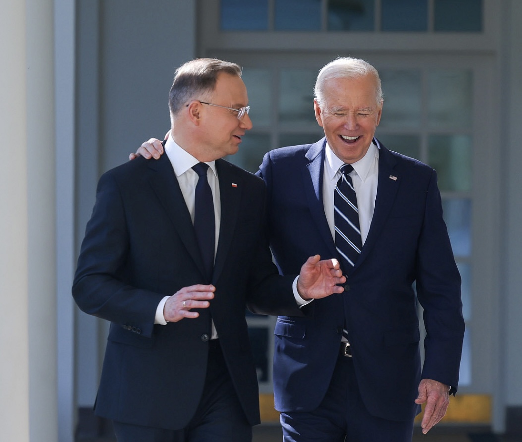 President Biden listens to President Duda speak as they walk at the White House
