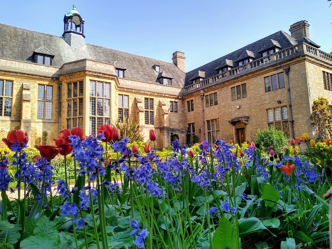 Spring flower border with the back of Rhodes House in the background.