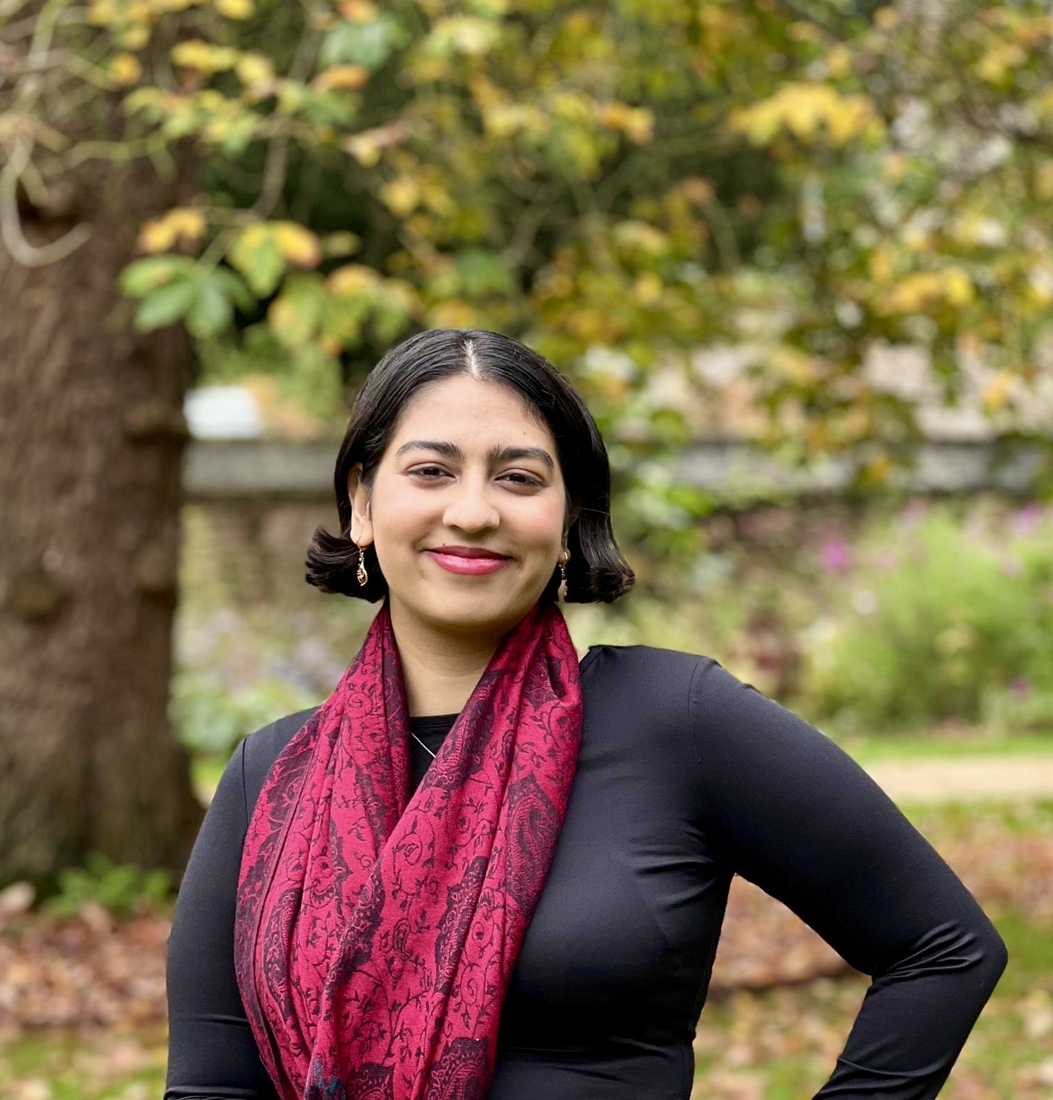 A headshot of Humairaa in front of an autumnal nature scene