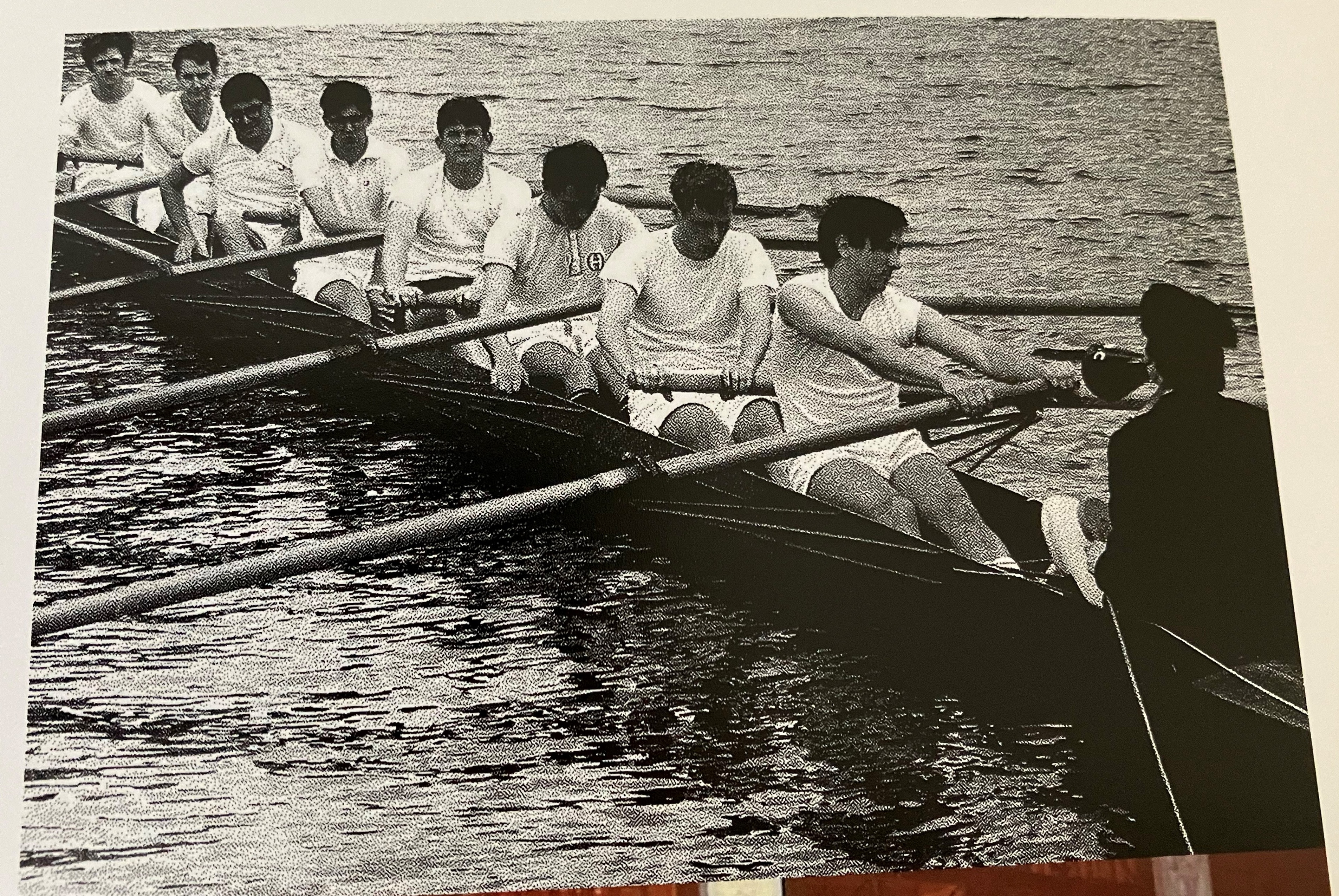 A black-and-white picture of people rowning.