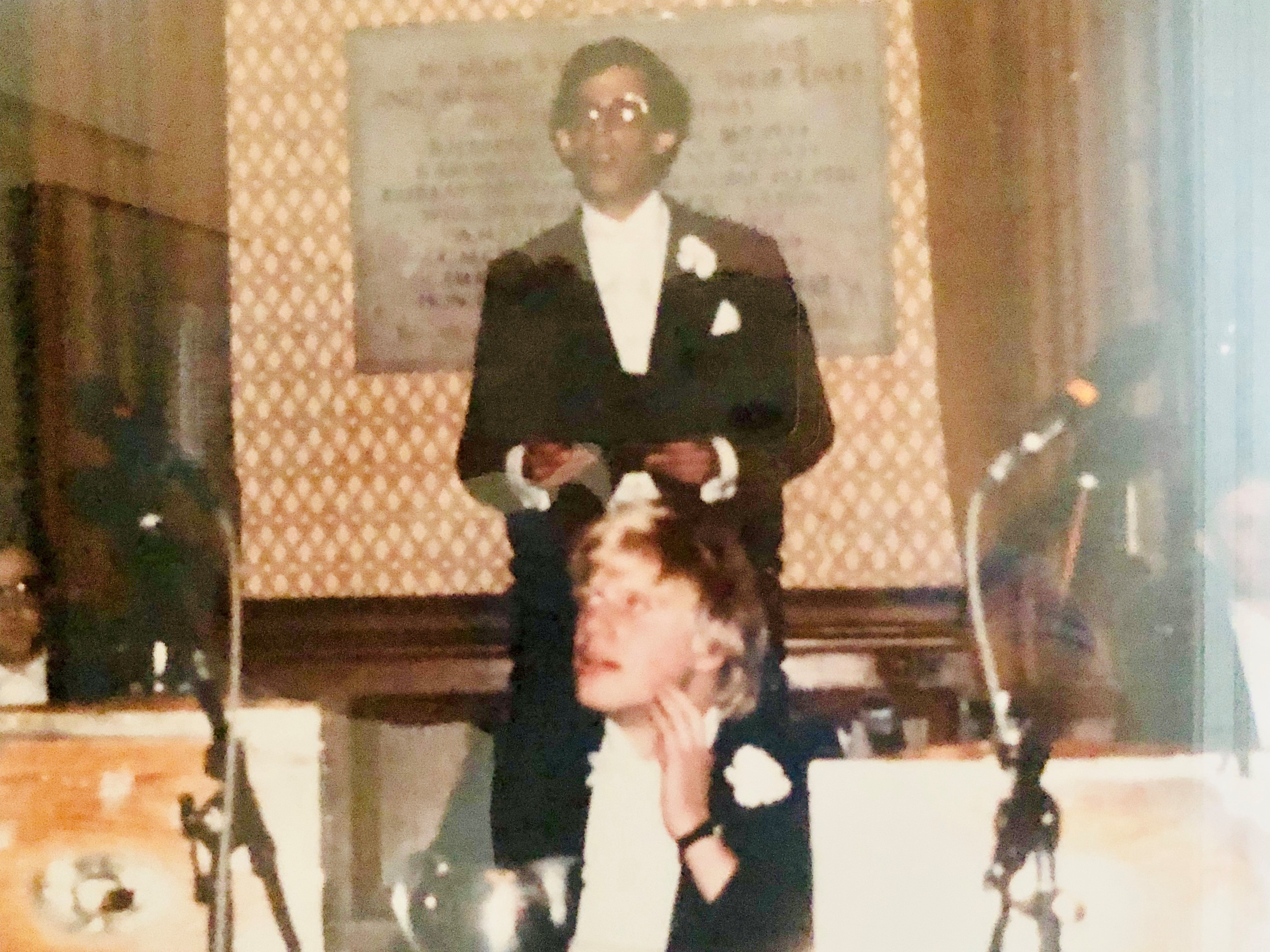 The picture shows Larry standing behind Boris Johnson. He is wearing a long robe. 