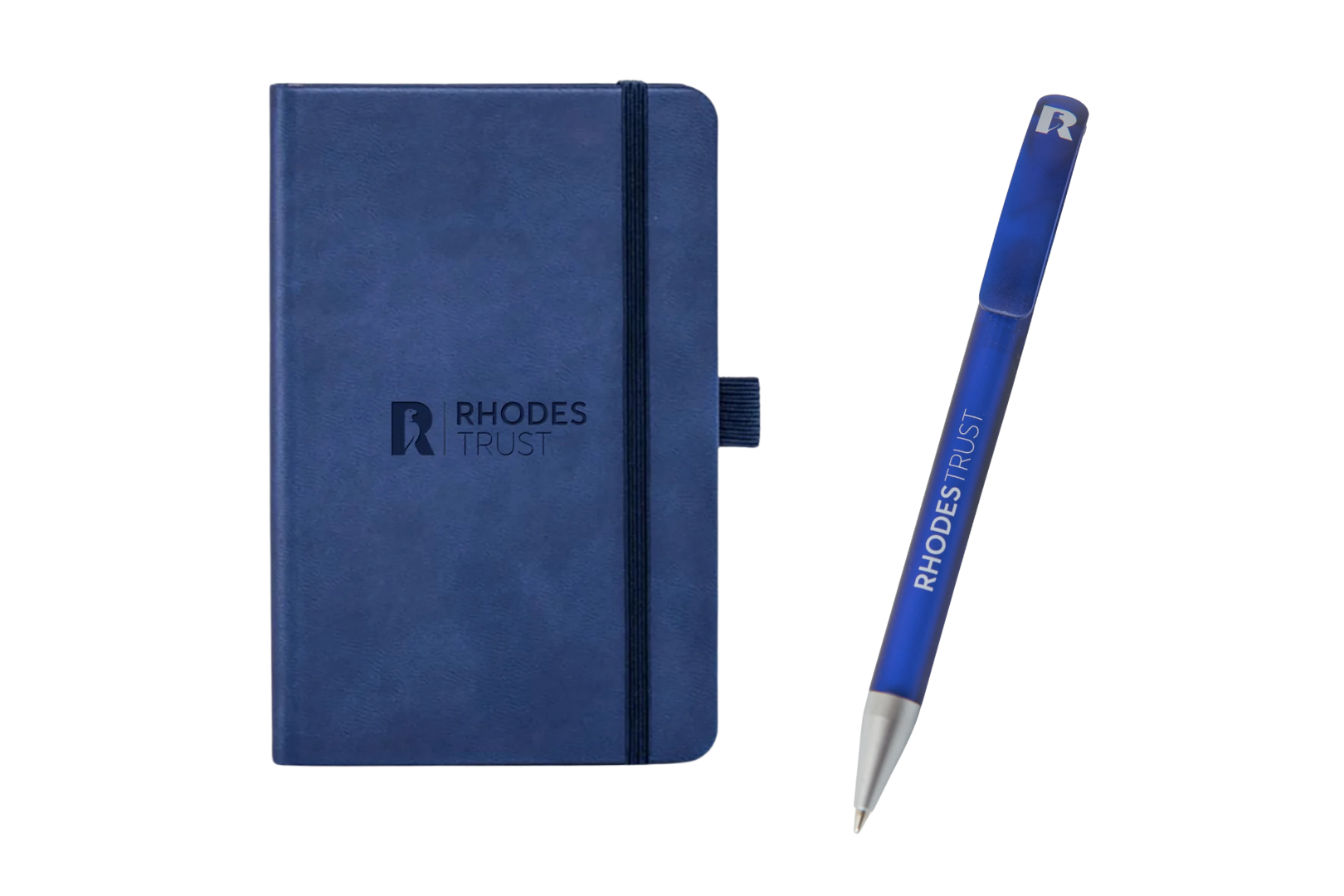 A navy blue hardback notebook with an elastic closure and pen loop, debossed with the Rhodes Trust logo, next to a translucent blue ballpoint pen printed with "Rhodes Trust" along its barrel.