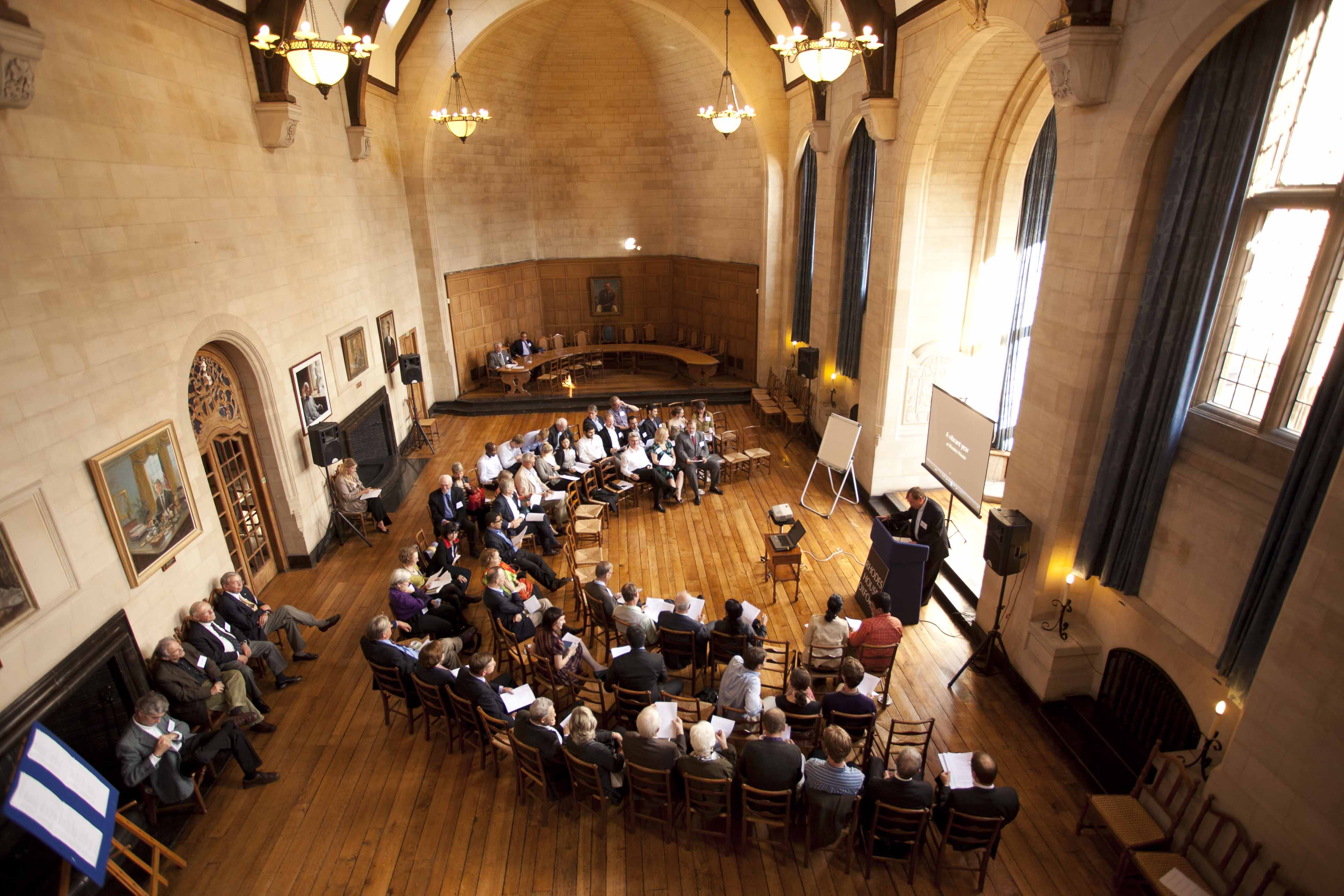 Rhodes House conference in McCall MacBain Hall with delegates in semicircle seating facing bay window