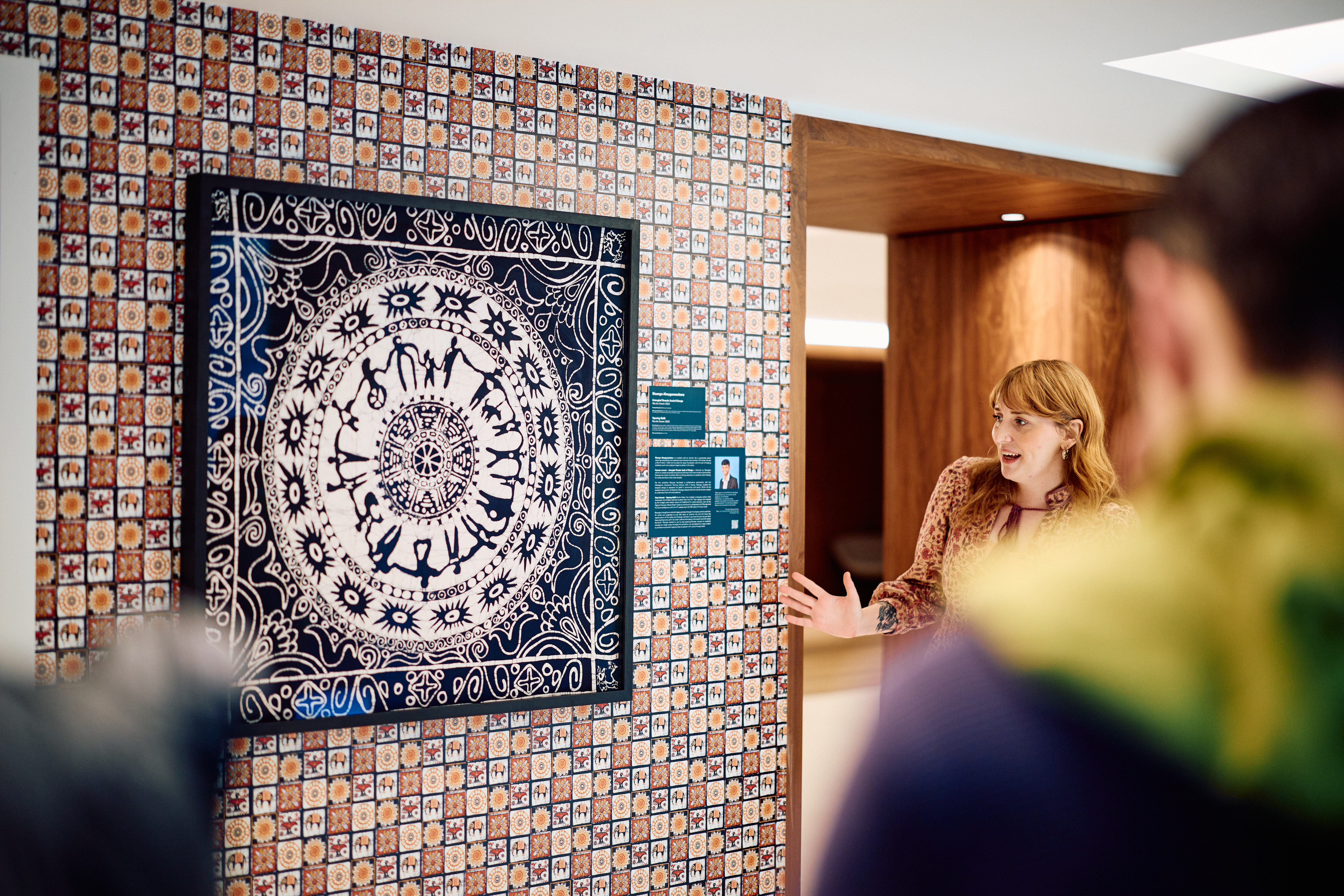 A woman discussing one of the artworks that features a batik design