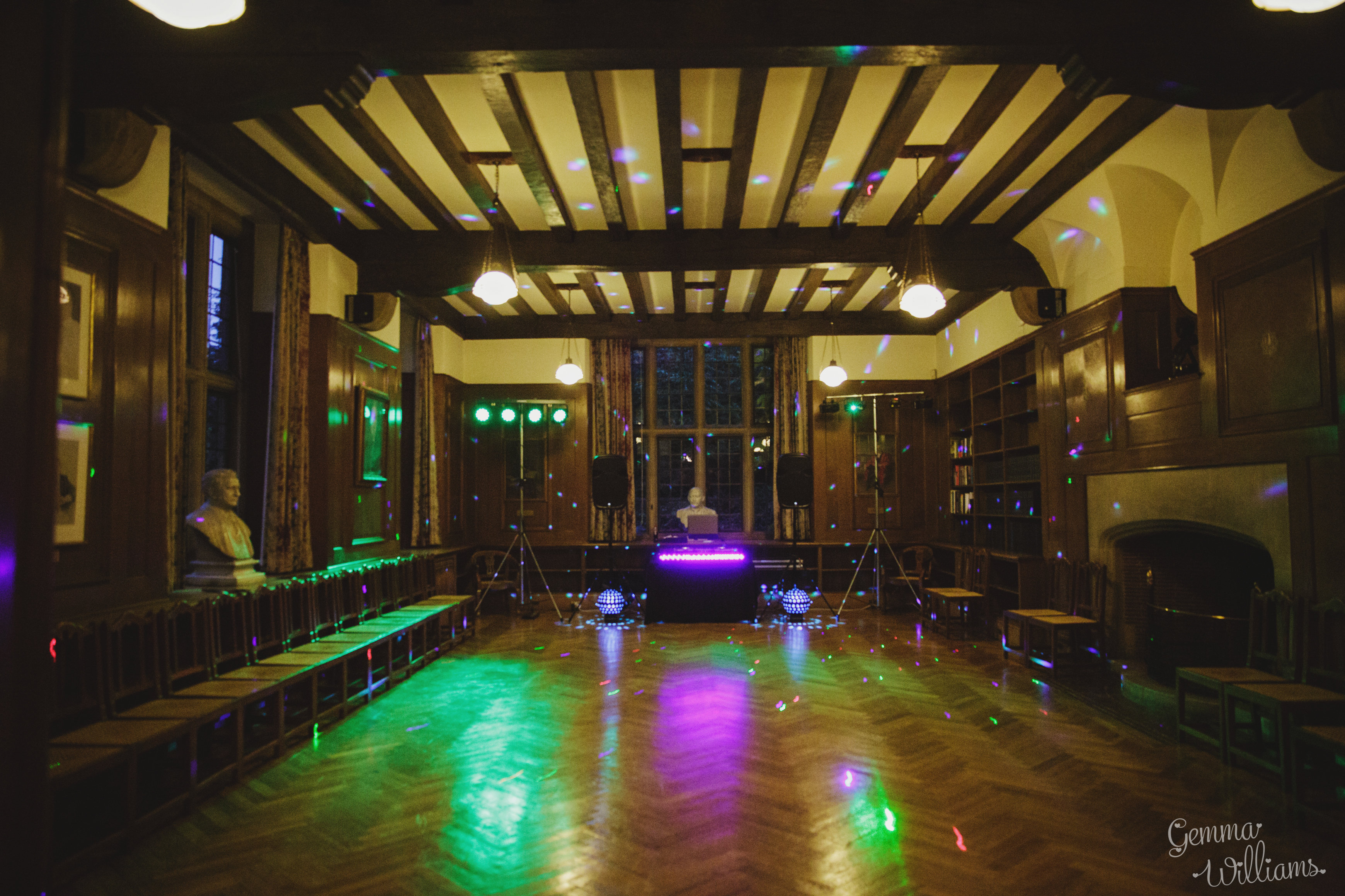 Rhodes House Beit Room set up for a disco with disco balls, lighting, and a DJ desk and speakers at the far end. Photo courtesy of Gemma Williams Photography.
