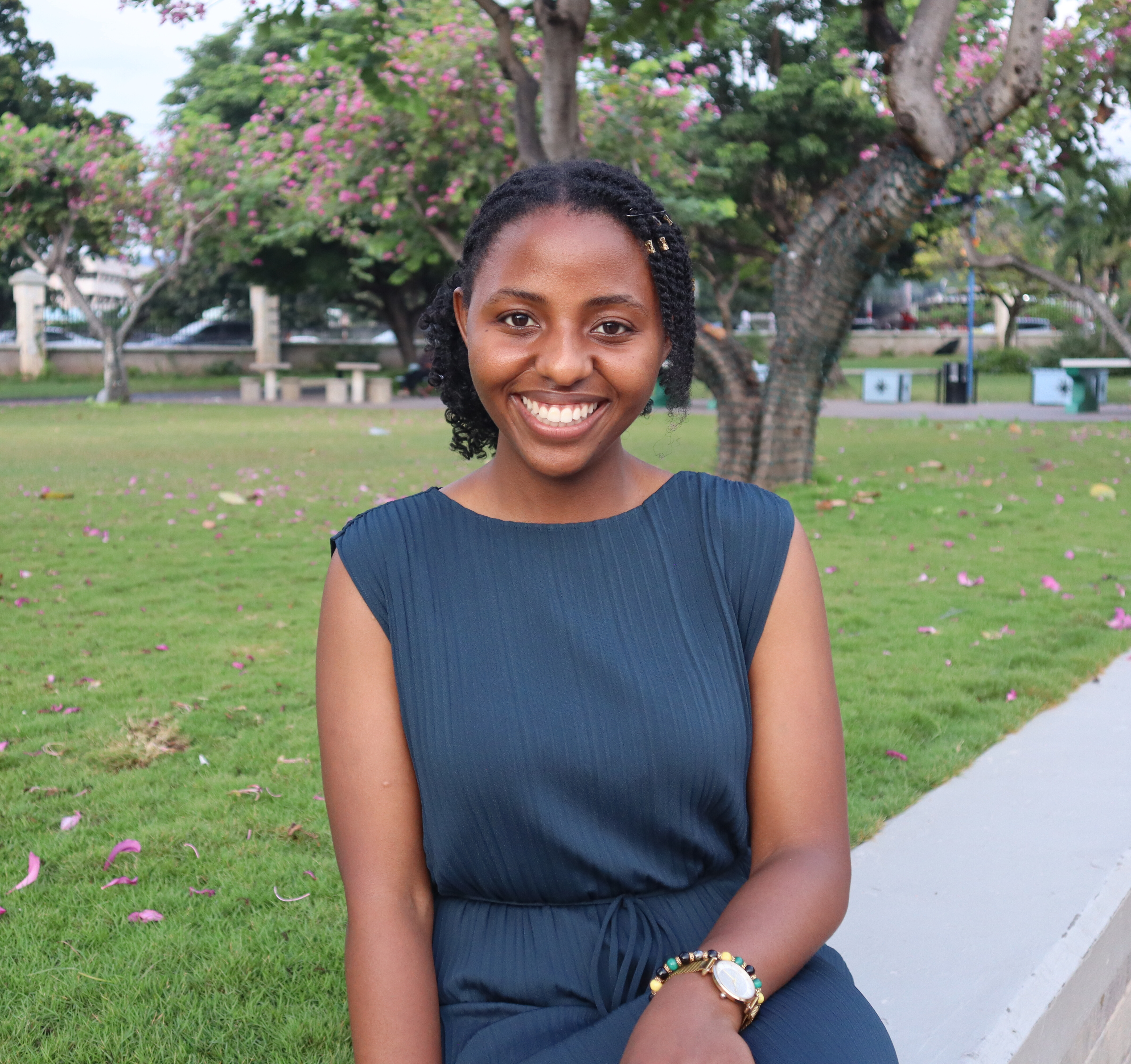Gloria smiling into the camera, with a park behind her