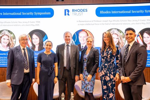 Photo shows 6 people in front of symposium backdrop