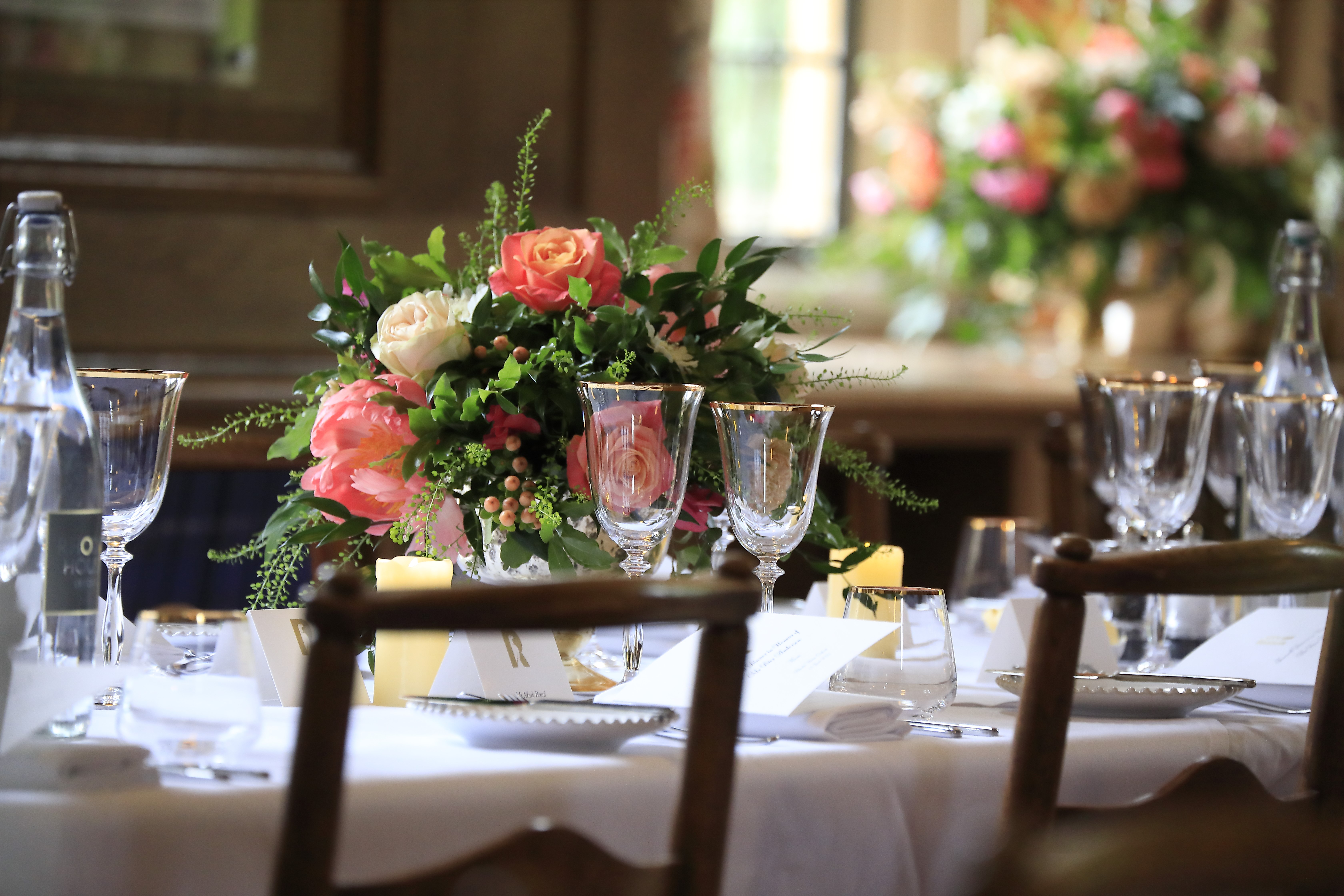 Pink flower arrangements on a dining table in the Rhodes House Beit Room.