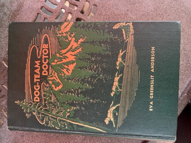 A book with the title 'Dog-team doctor'. The cover shows silhouettes of dogs walking a path. The writer is 'Eva Greenslit Anderson'.
