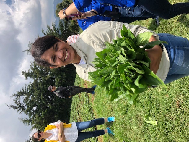 Sherry-Lee stood, smiling on a form holding green crops.
