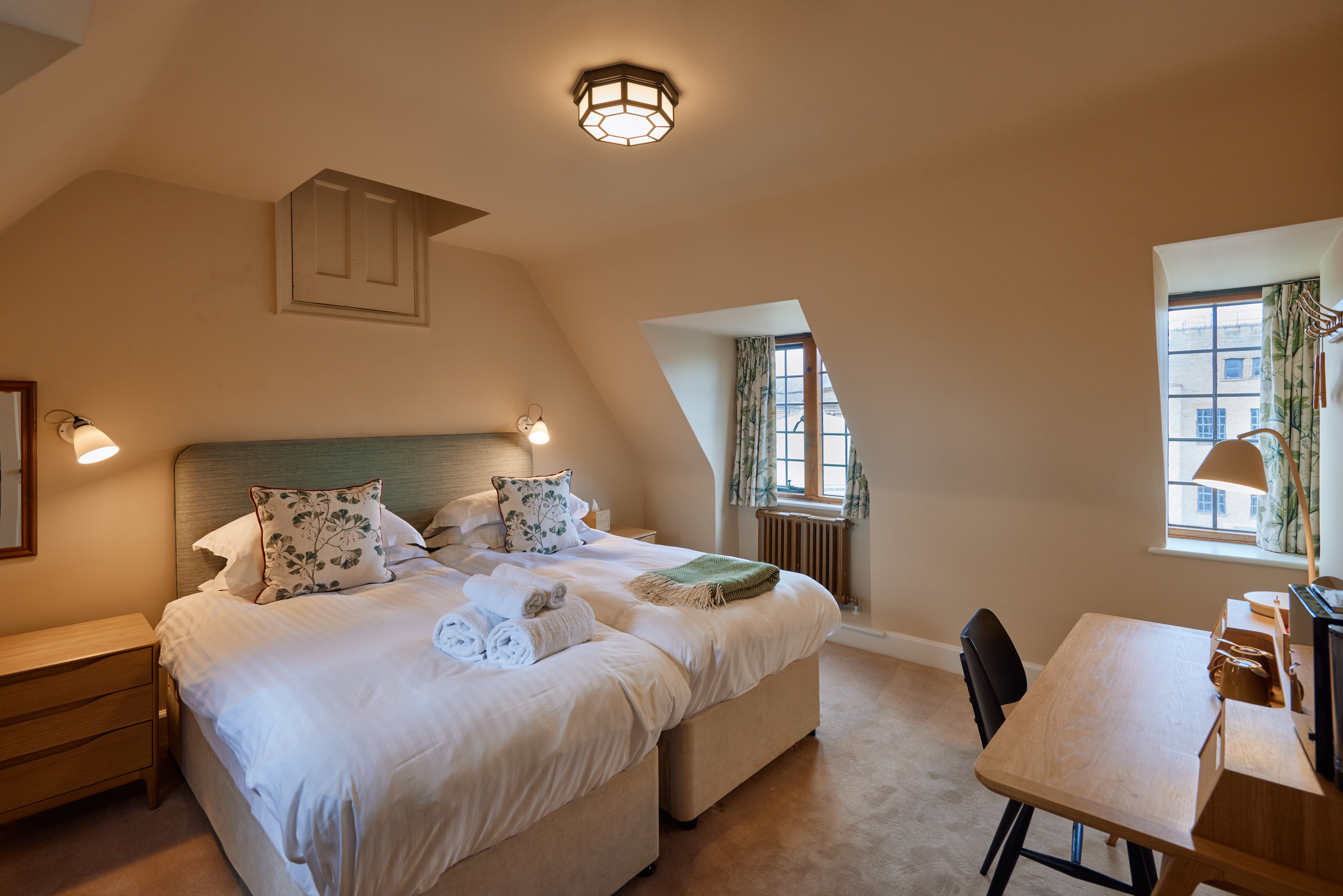 Rhodes House accommodation - A double Bedroom With Two Single Beds Pushed Together; Two Windows With Floral Curtains Let Light Into The Room