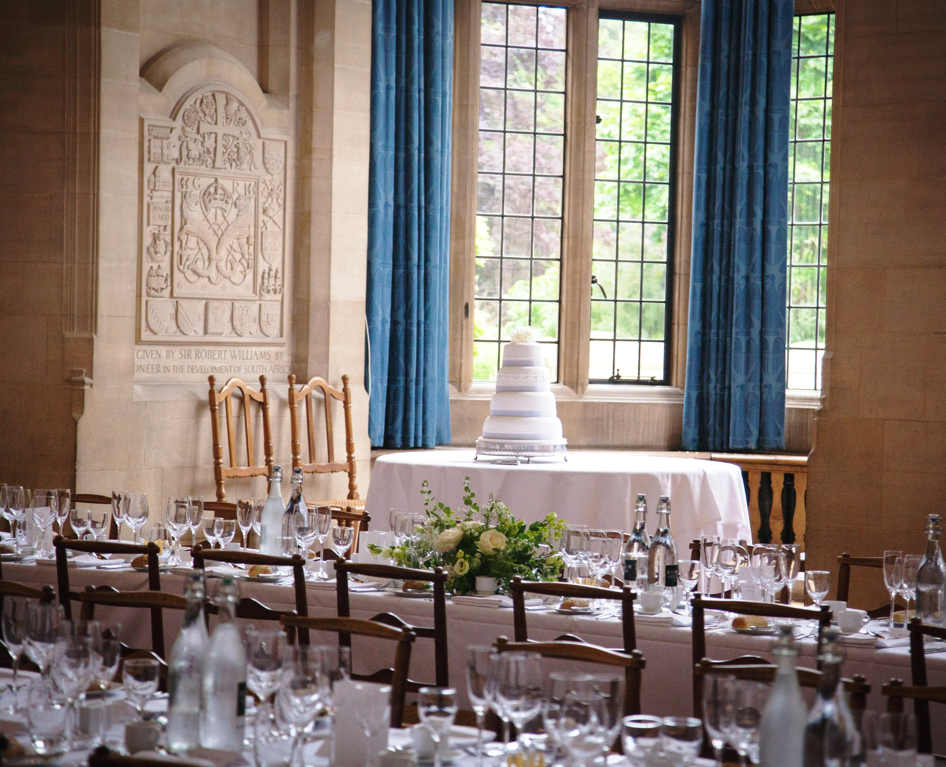 Wedding Cake On A Table In The Rhodes House McCall MacBain Hall Bay Window with wedding dinner tables in foreground.