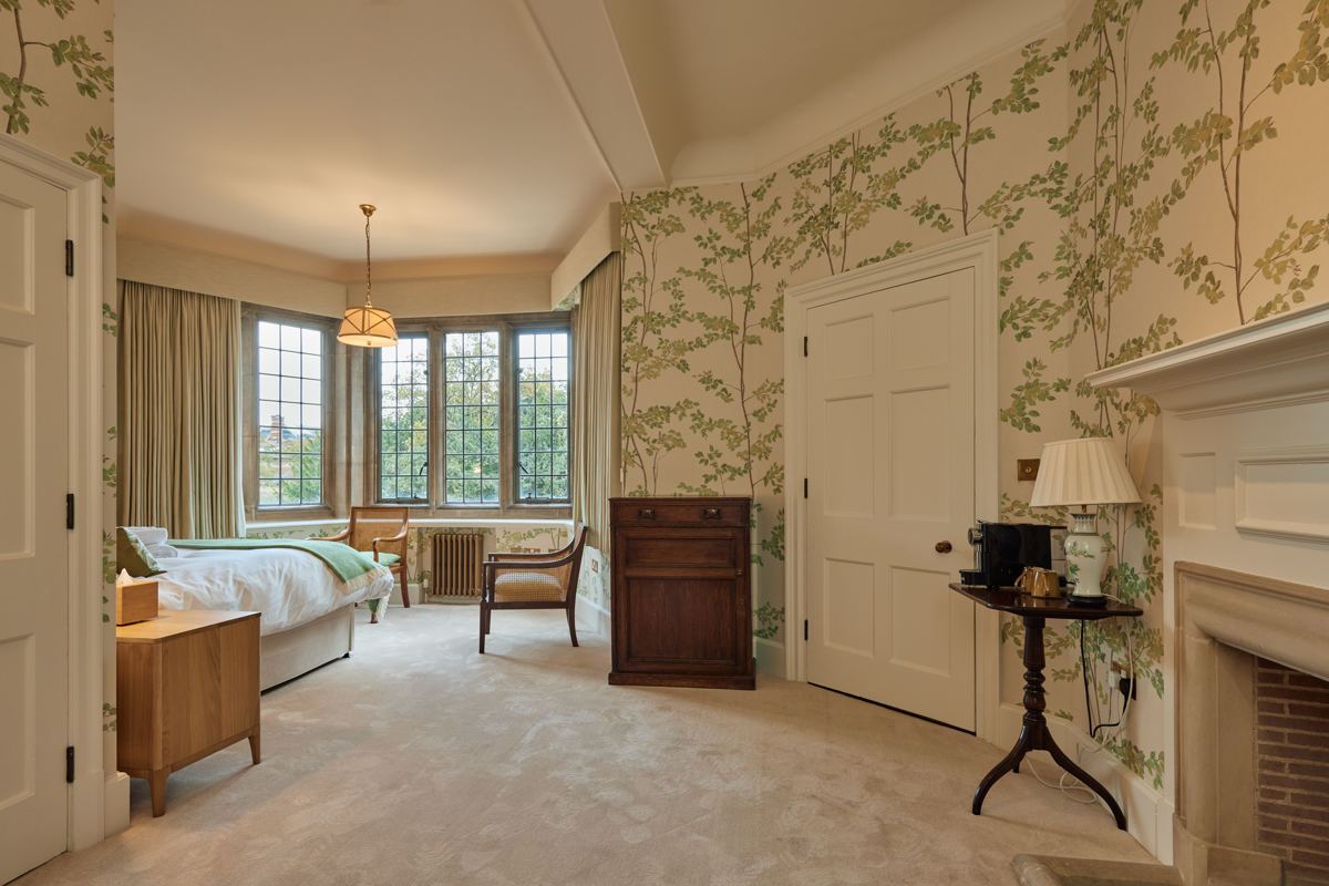Rhodes House accommodation - Period Accessible double bedroom with sage green wallpaper and a view of the bay window. 