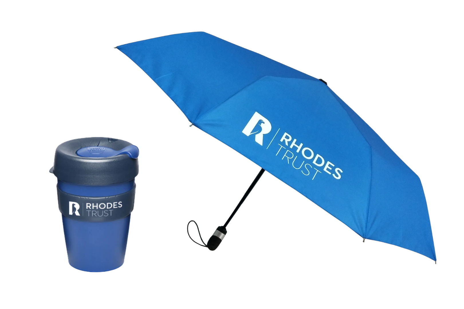 A blue reusable KeepCup coffee cup with a navy lid and band printed with the white Rhodes Trust logo, next to an open bright blue umbrella with a large white Rhodes Trust logo on one panel.