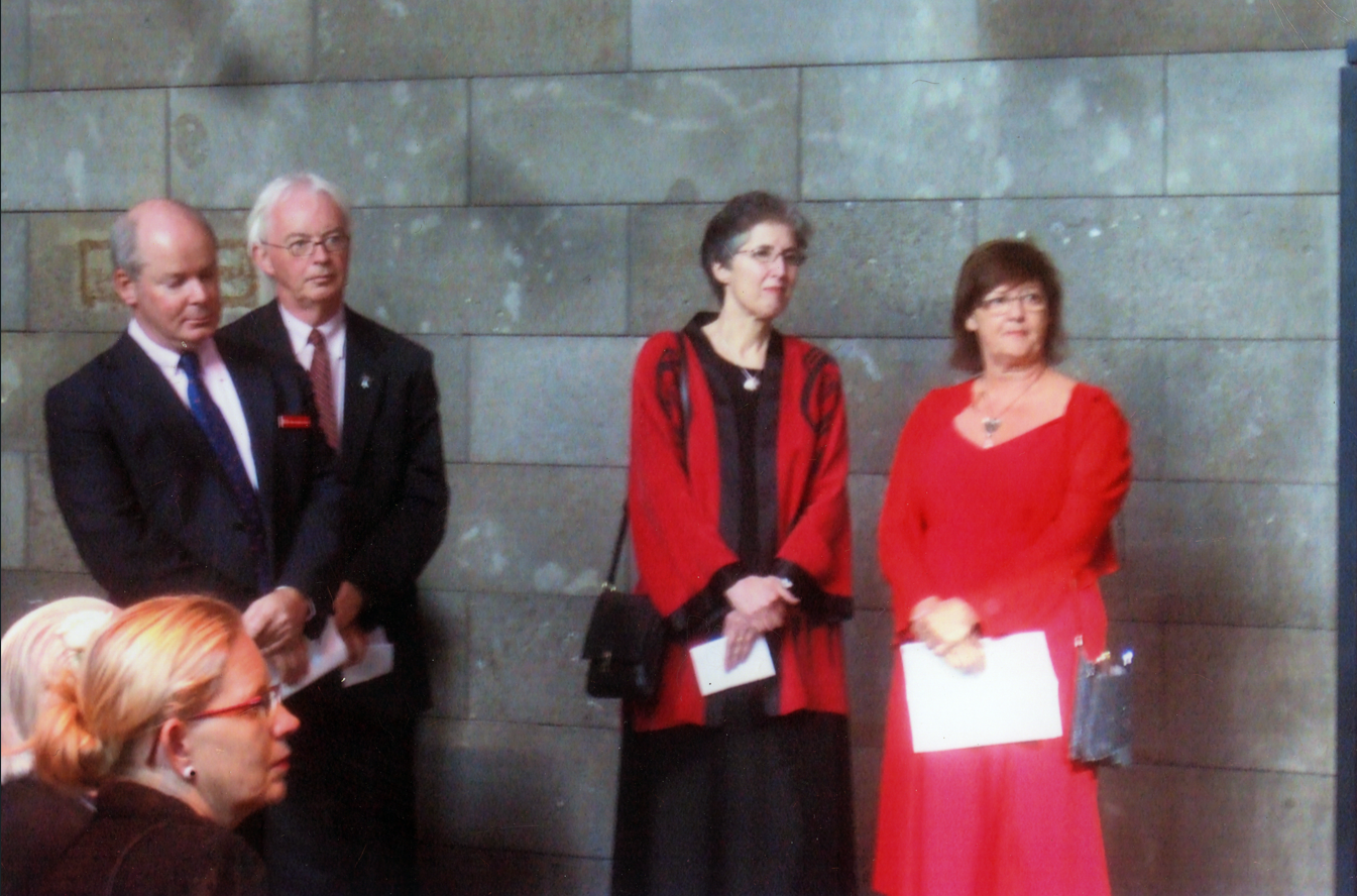 A picture showing Jaynie in a red dress with other participants, formally dressed 