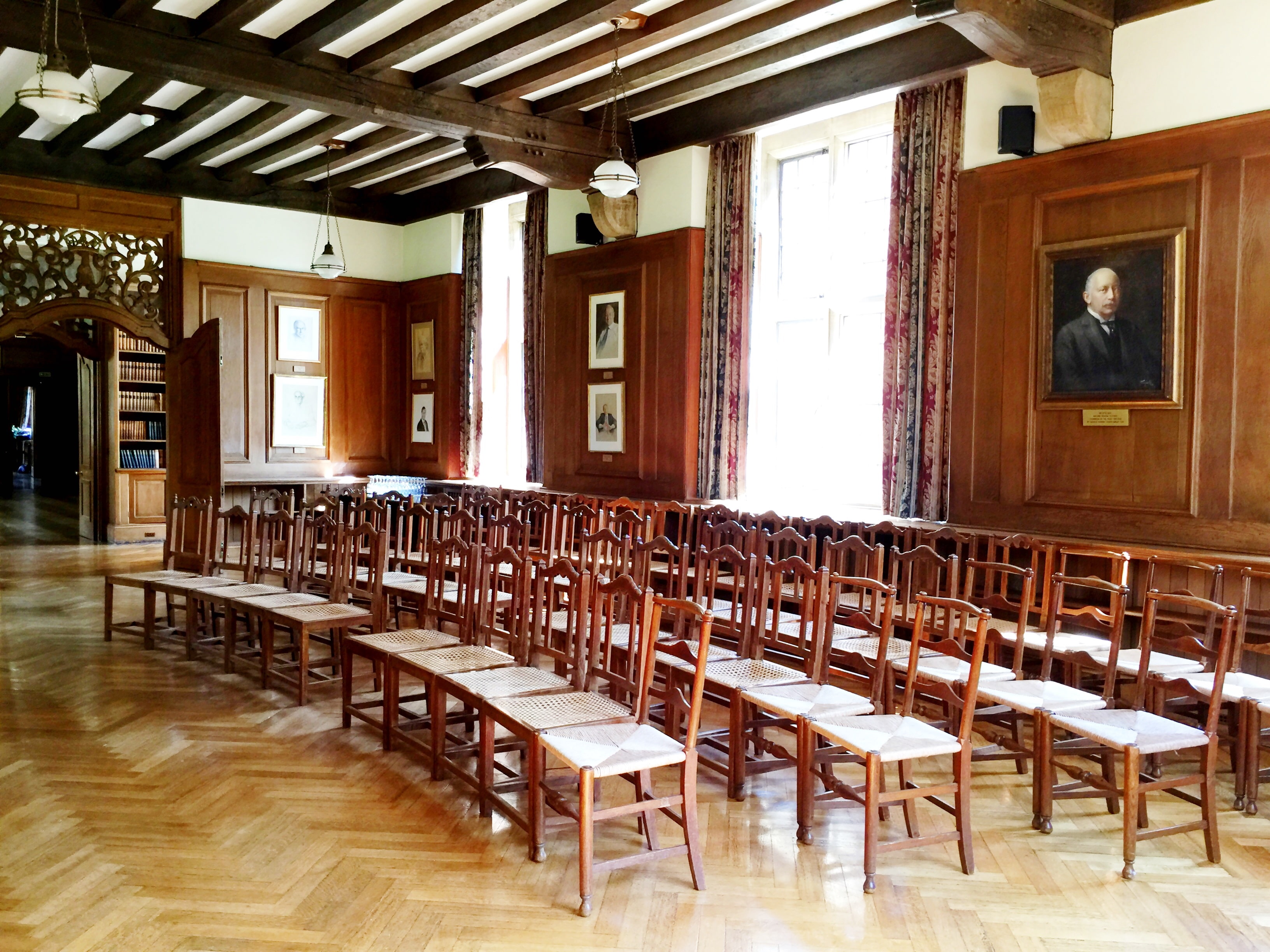 Chairs set up for a small meeting in a curved arch layout in the Rhodes House Beit Room 