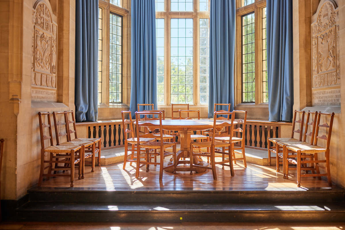 Bay window in Rhodes House McCall MacBain Hall in the daytime, with round table and chairs. 