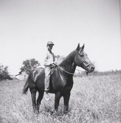 Black and white childhood photo of Greg as a child on horse.