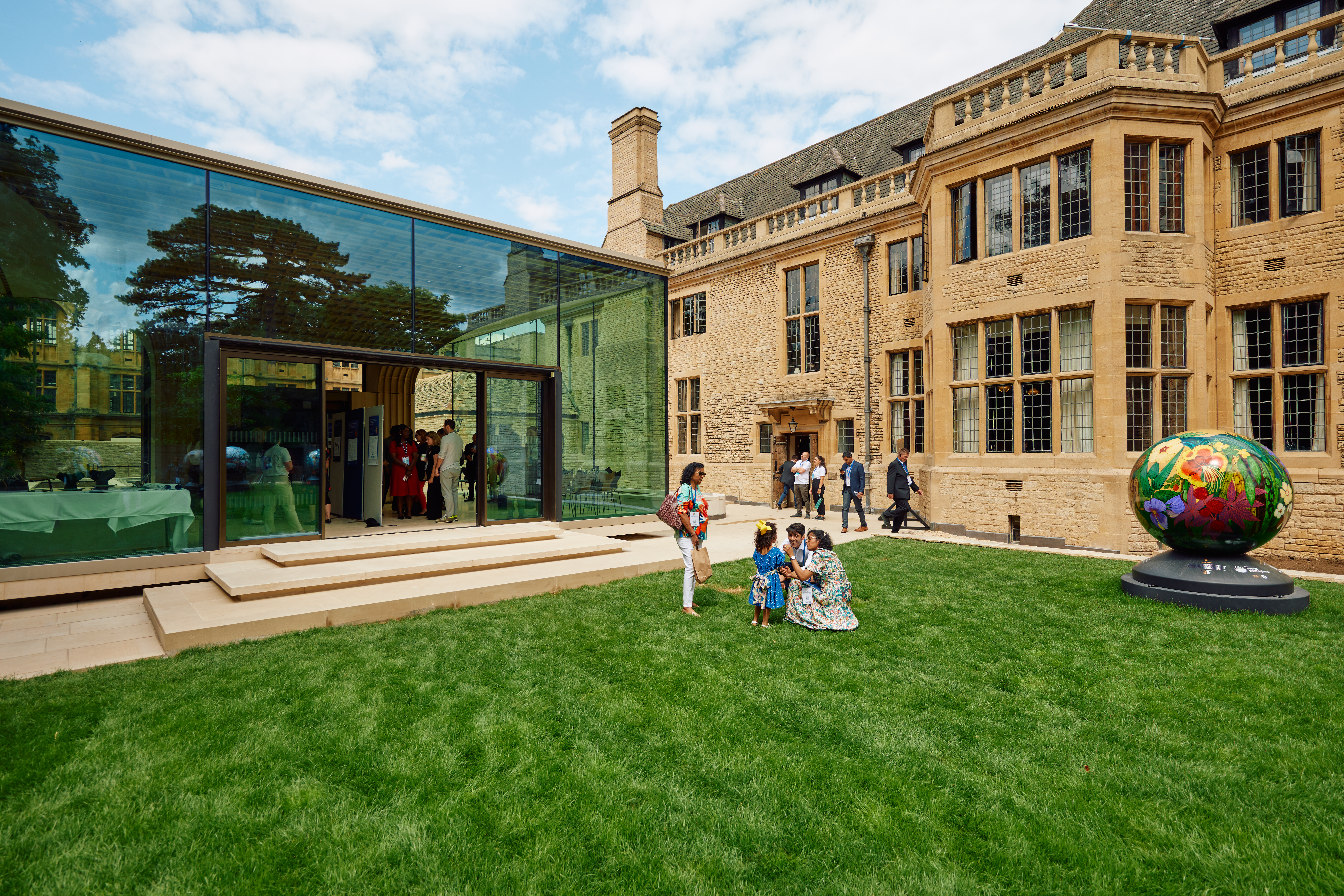 Guests at a reception on the Rhodes House West Lawn in front of the Glass Pavilion