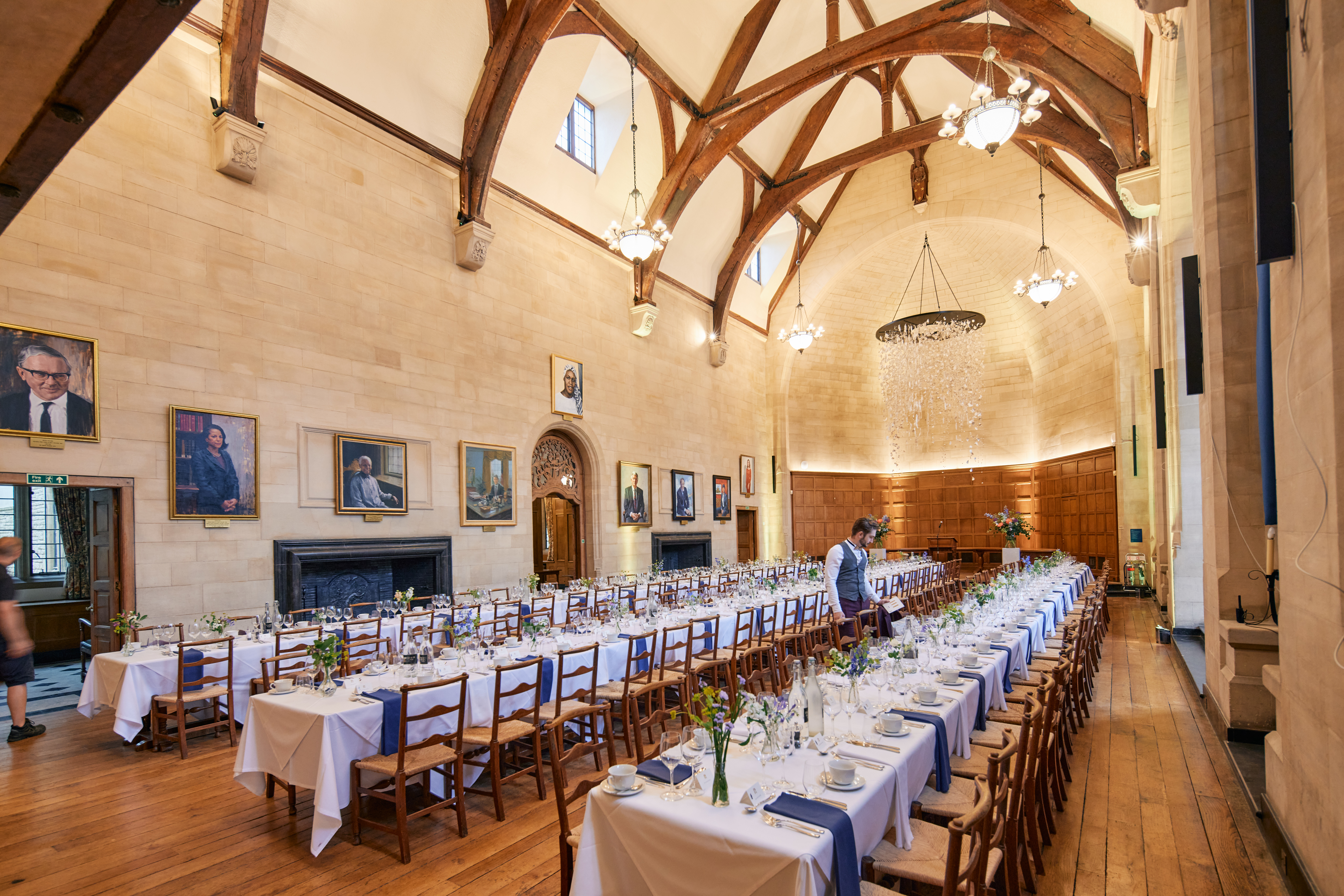 A Single Waiter Setting Places In Rhodes House McCall MacBain Hall for a private dinner.
