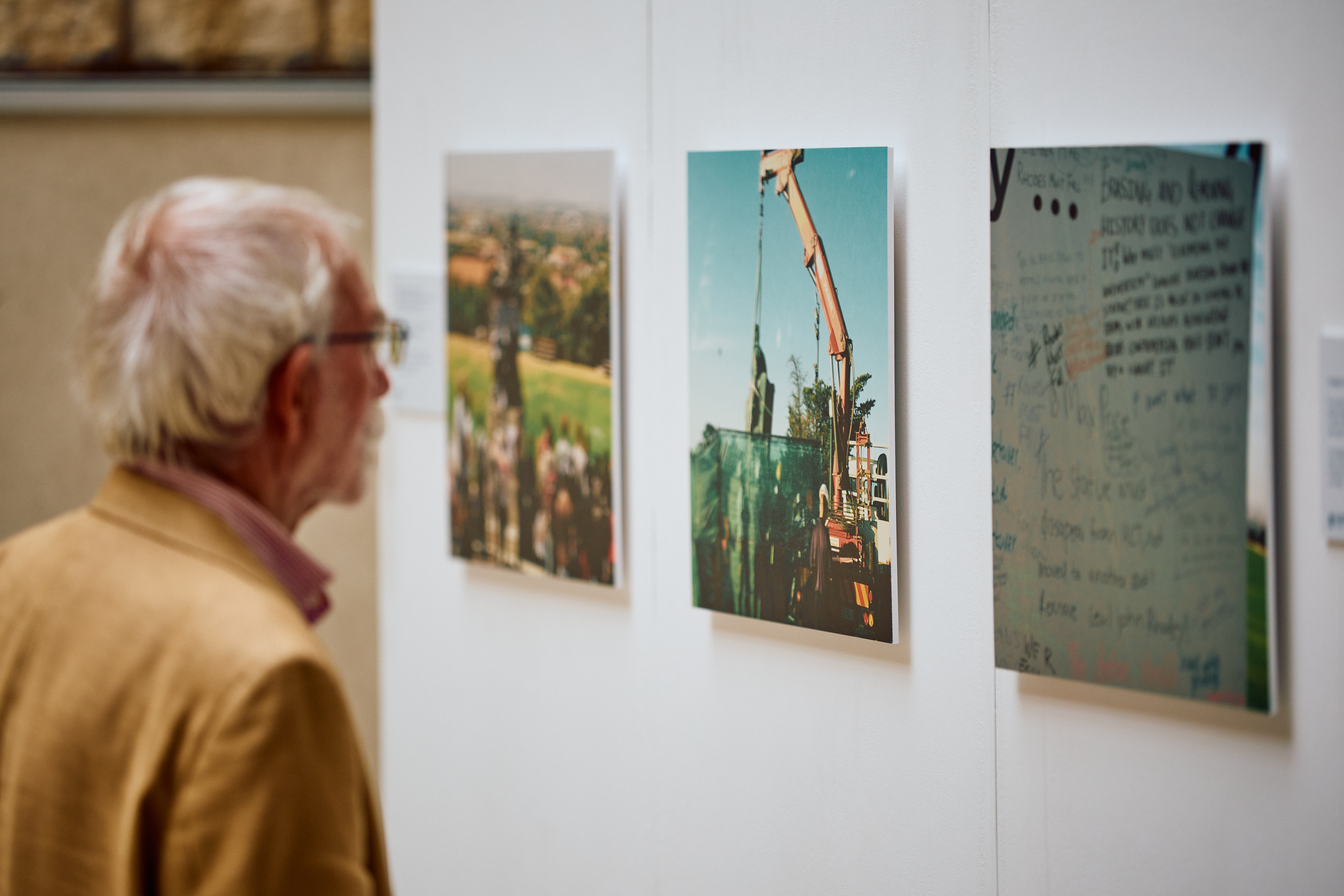 Older Man Looking At The Photographs Part Of The Exhibition By Shadreck