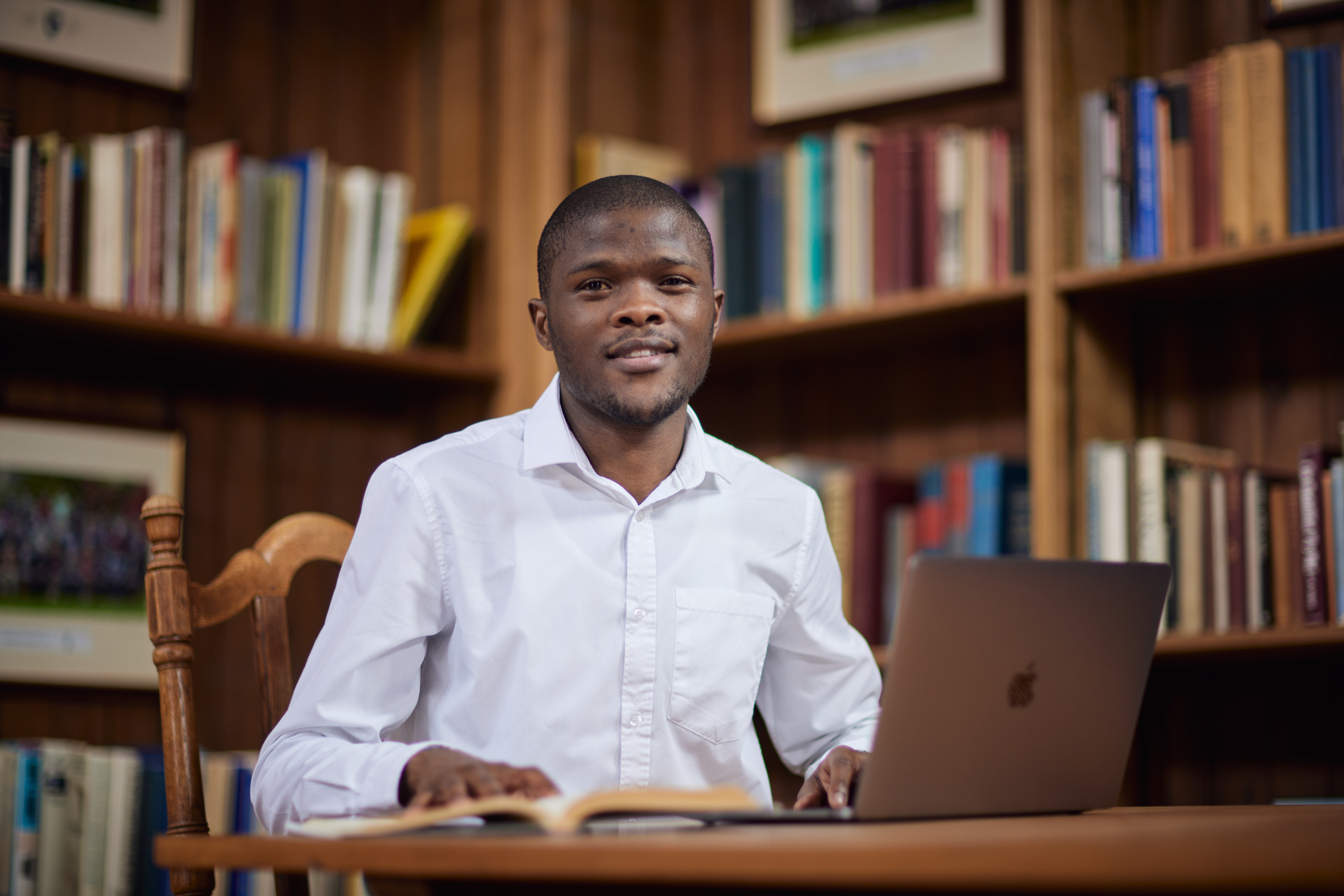 A man in a white shirt sitting in the Rhodes House library