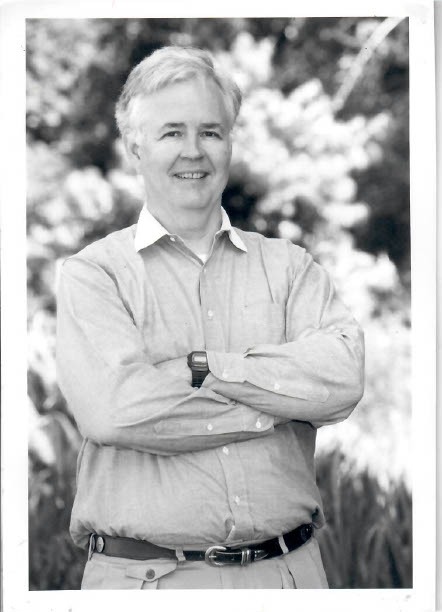 A black-and-white picture of an older Norton. He's standing with his arms crossed.