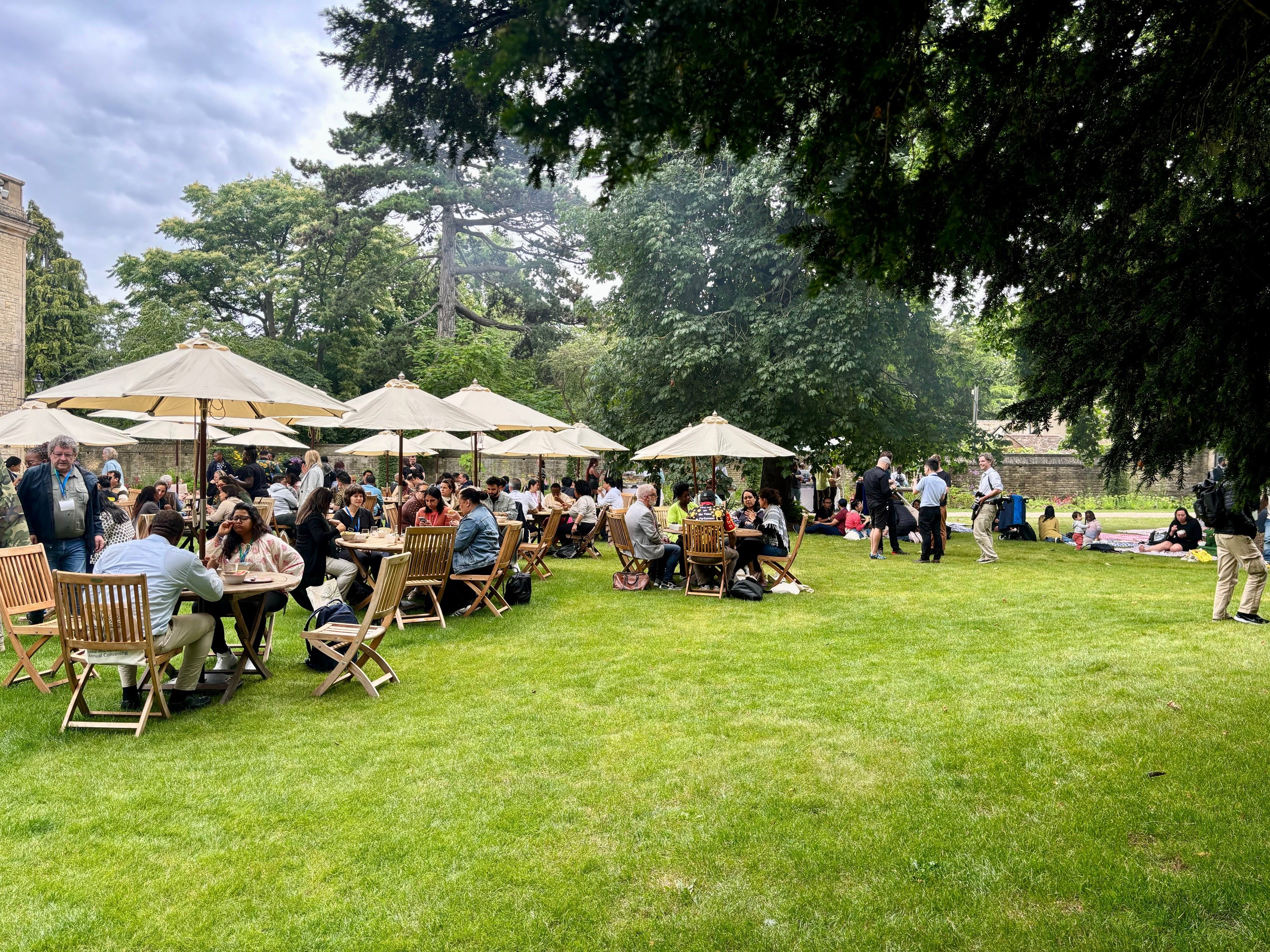 Garden party at Rhodes House with guests seated out outdoor chairs in the West Garden.