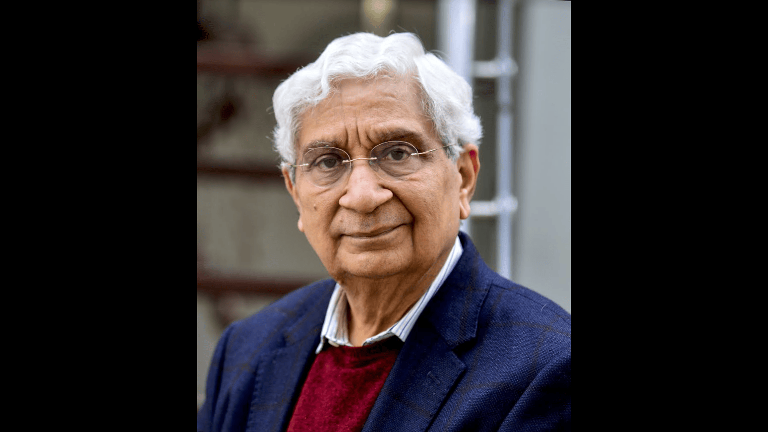 A close-up portrait of Deepak in a blue jumper and a navy jacket