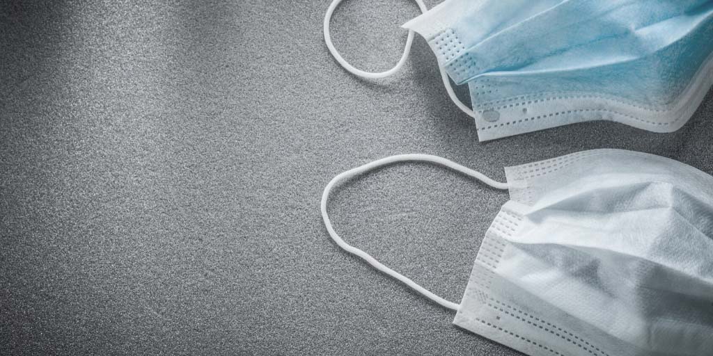 An image of two surgical facemasks laid out on a table