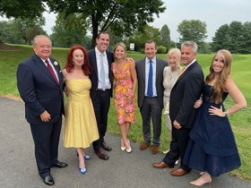 Nick and his family stood before a garden all dressed up.