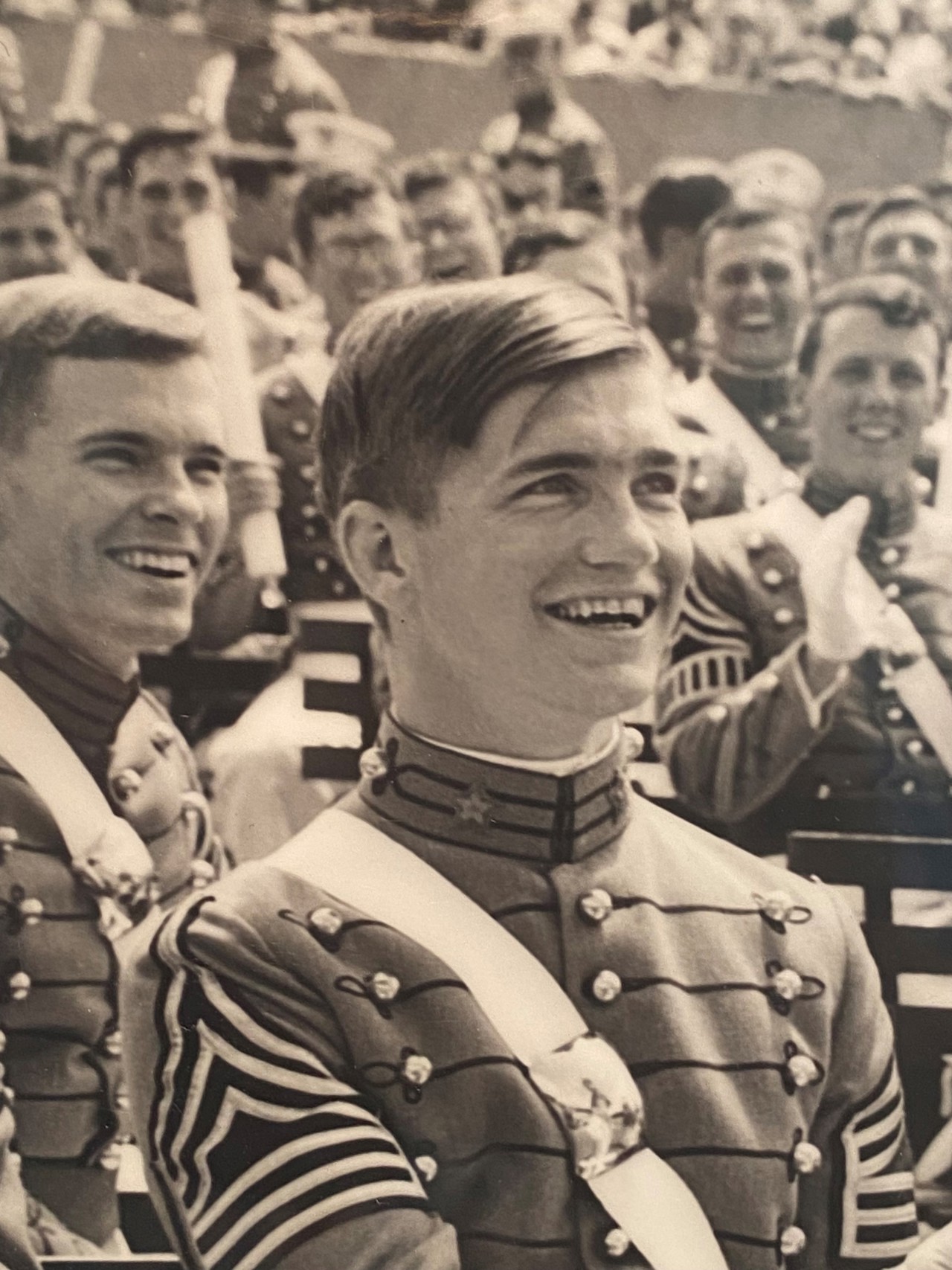 A black-and-white picture of a smiling Jack in his graduation attire from West Point