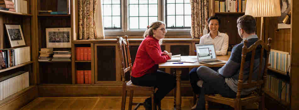 Scholars in discussion around a table in the Rosebery library