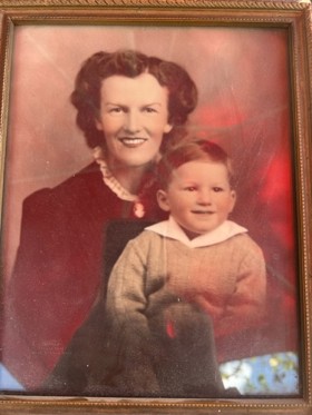A framed photograph of a woman with a little baby in her arms. They are both smiling.