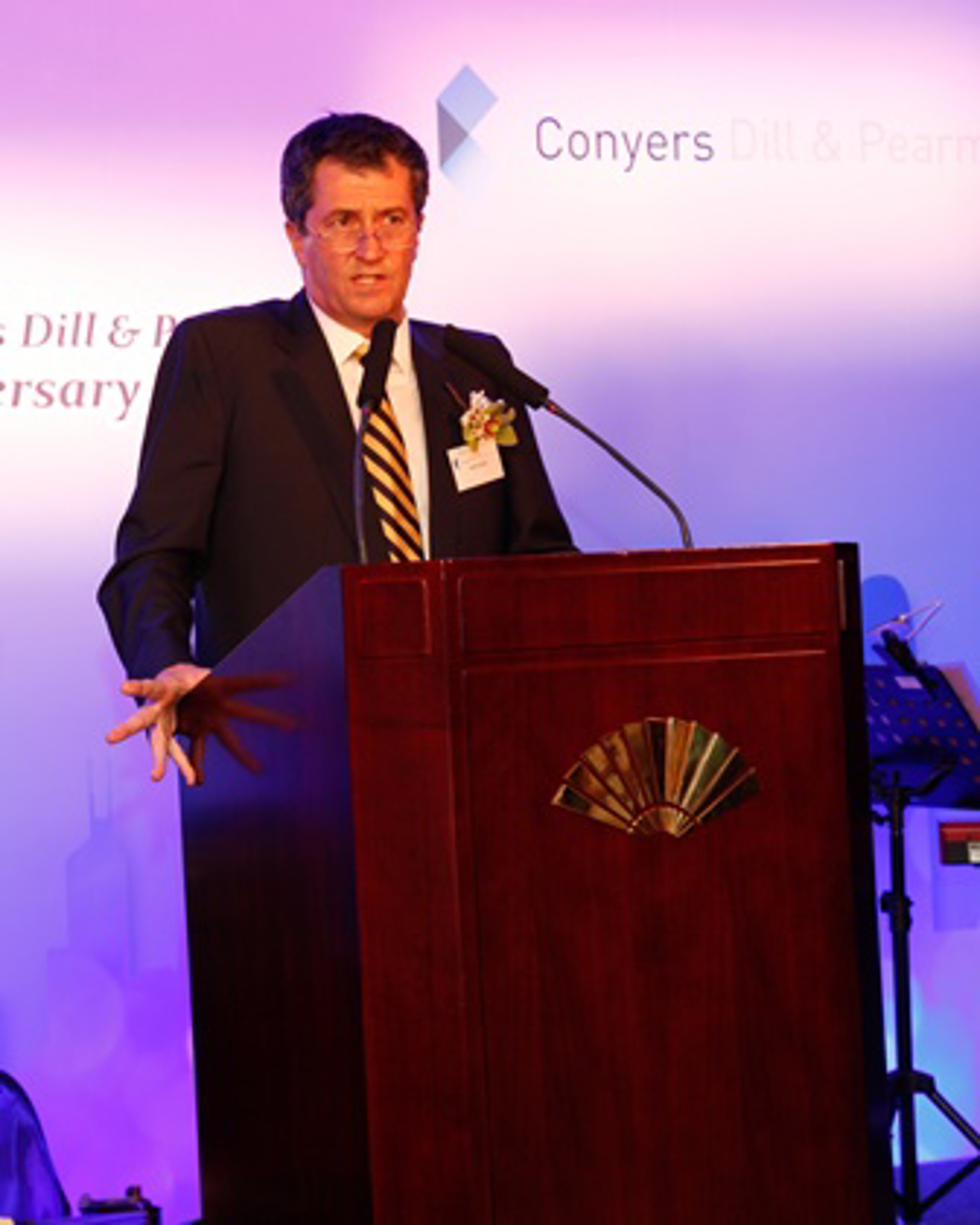 The picture shows John standing at the podium, giving a speech.