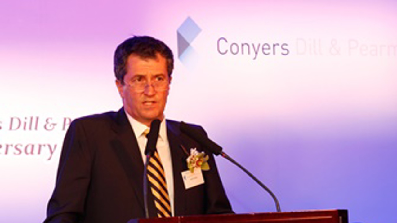 The picture shows John standing at the podium, giving a speech.