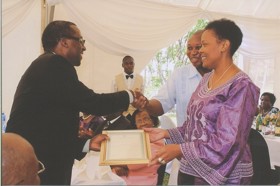 Kenneth shaking hands, smiling, accepting certificate.
